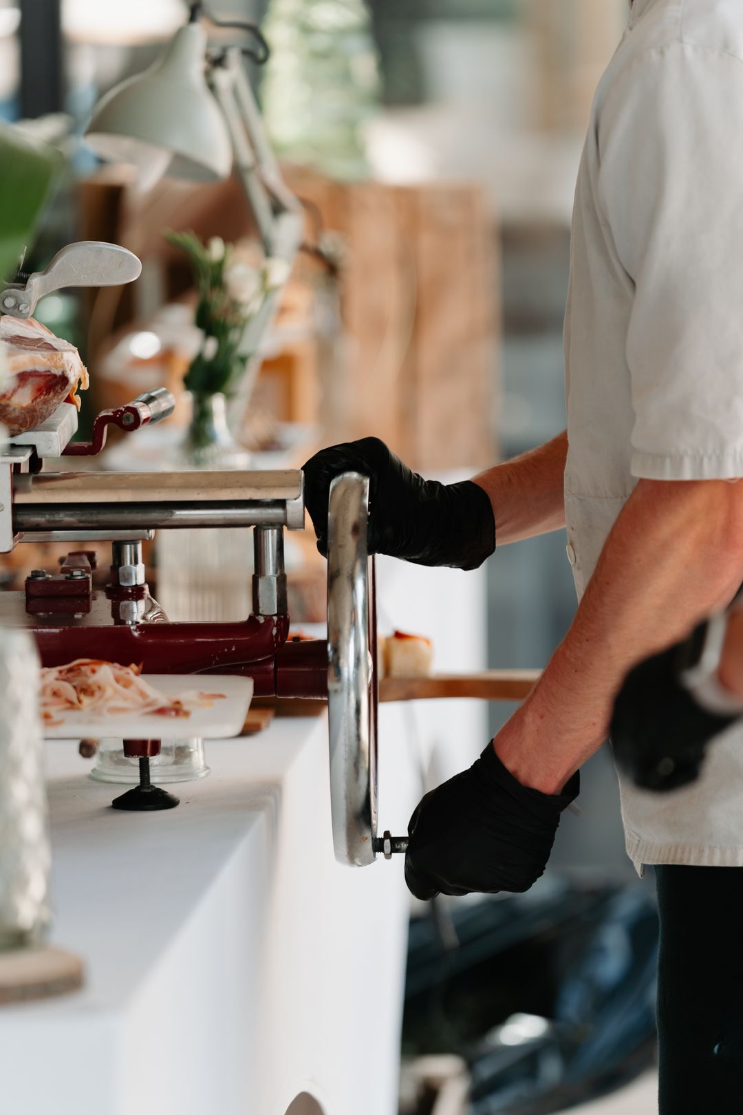 Close-up view of hands preparing food in a professional kitchen setting.