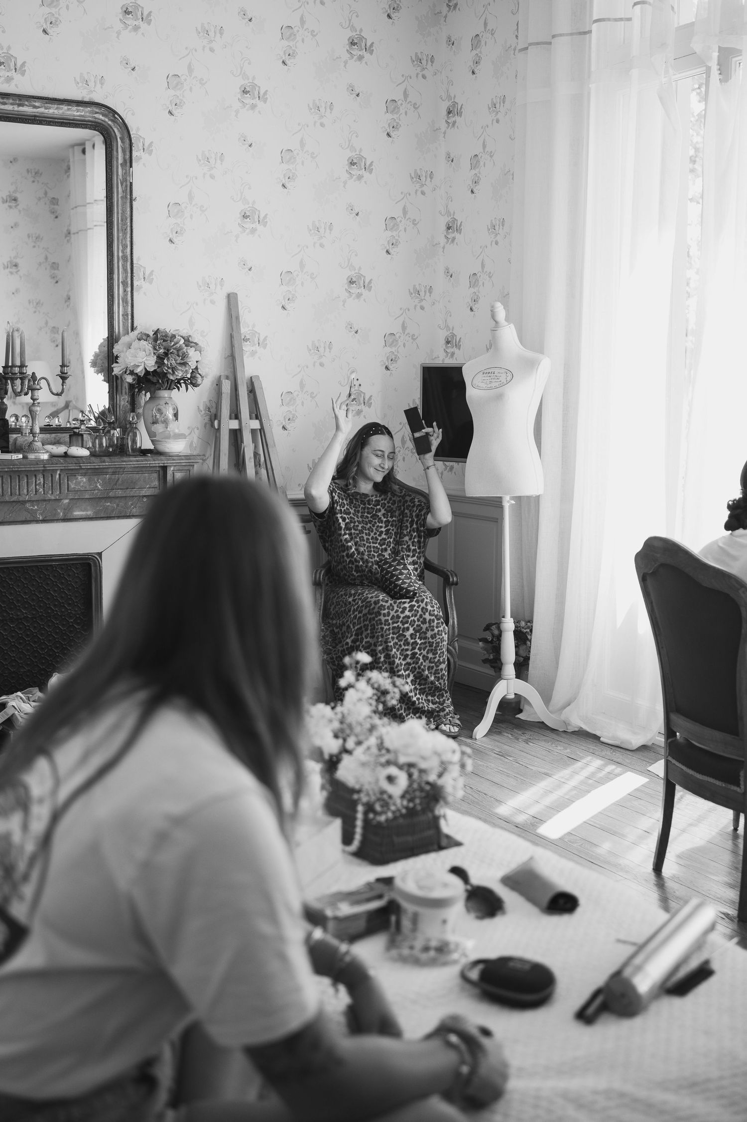 Black and white getting ready photos showing wedding preparations in a vintage-styled room.