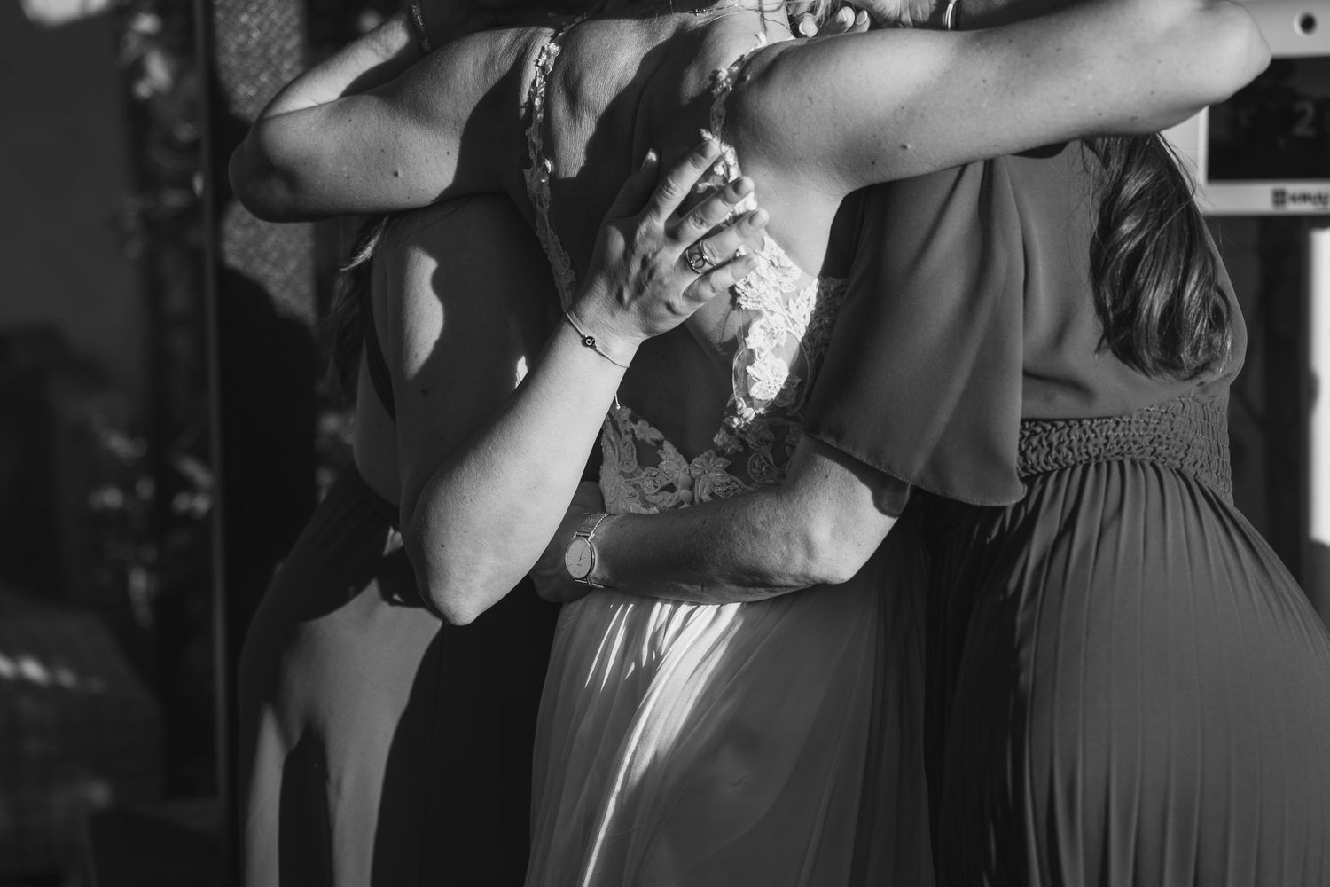 Wedding guests dancing together on a dimly lit dance floor at an evening reception celebration.