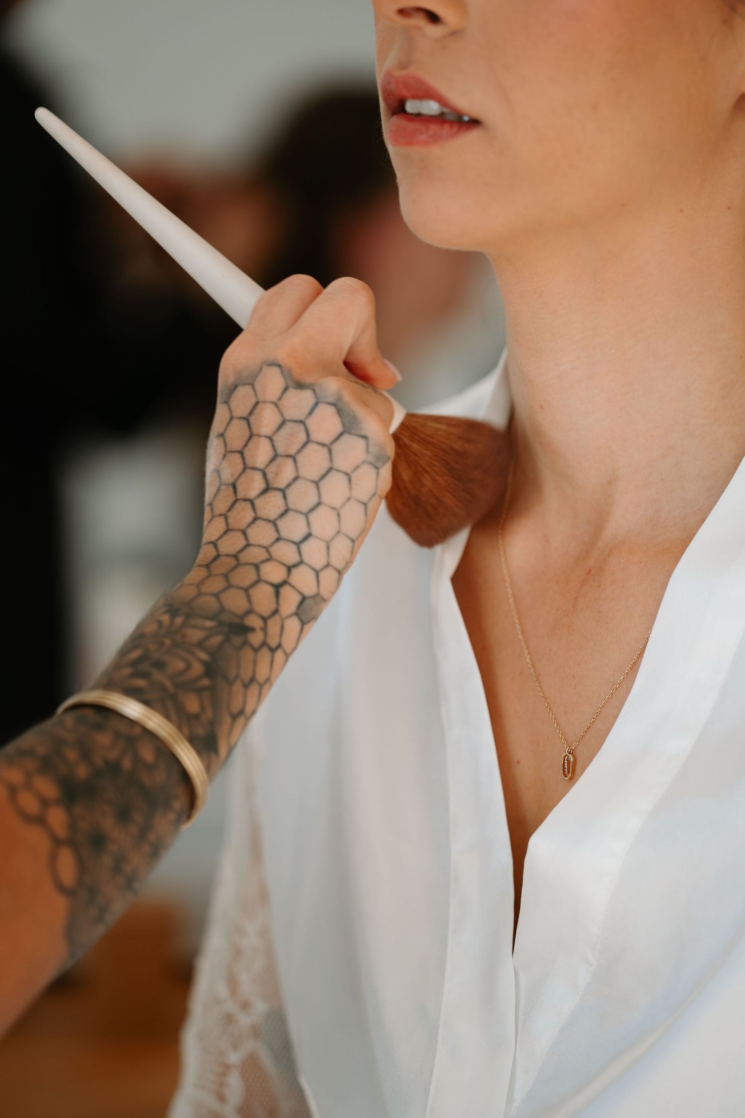 A series of close-up shots showing a honeycomb pattern tattoo on an arm wearing a white shirt.