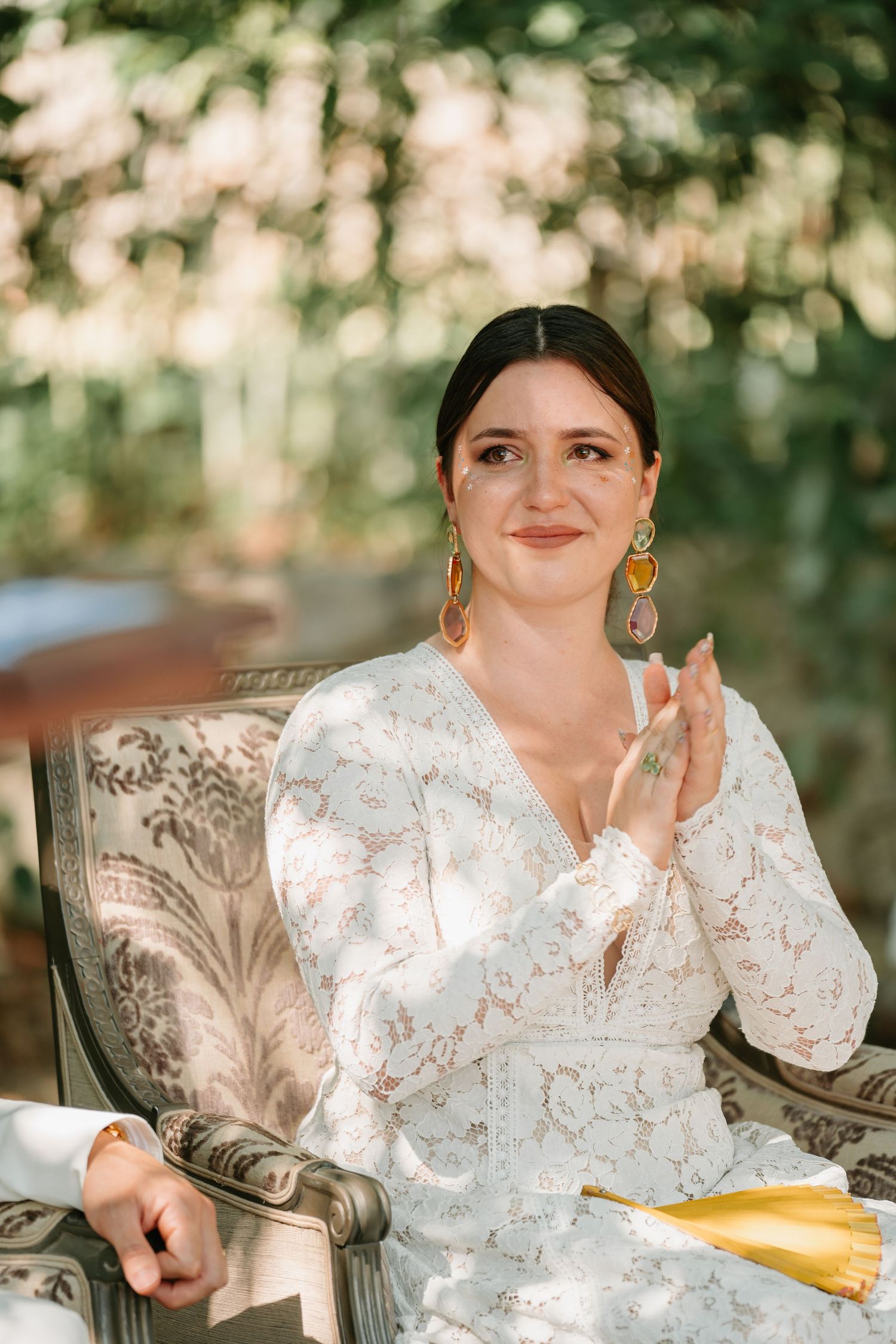 A series of candid portraits showing someone in a white floral dress sitting in an elegant chair outdoors.