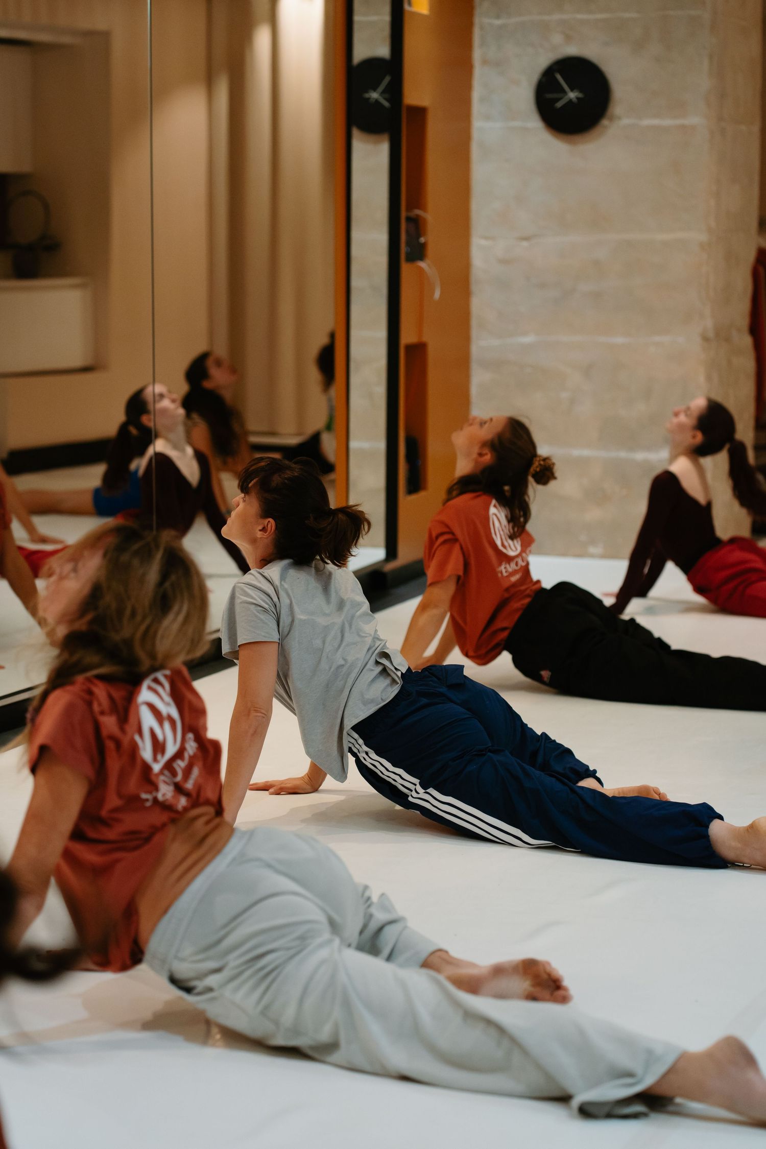 Dance students practice floor exercises in a studio during a contemporary dance class.