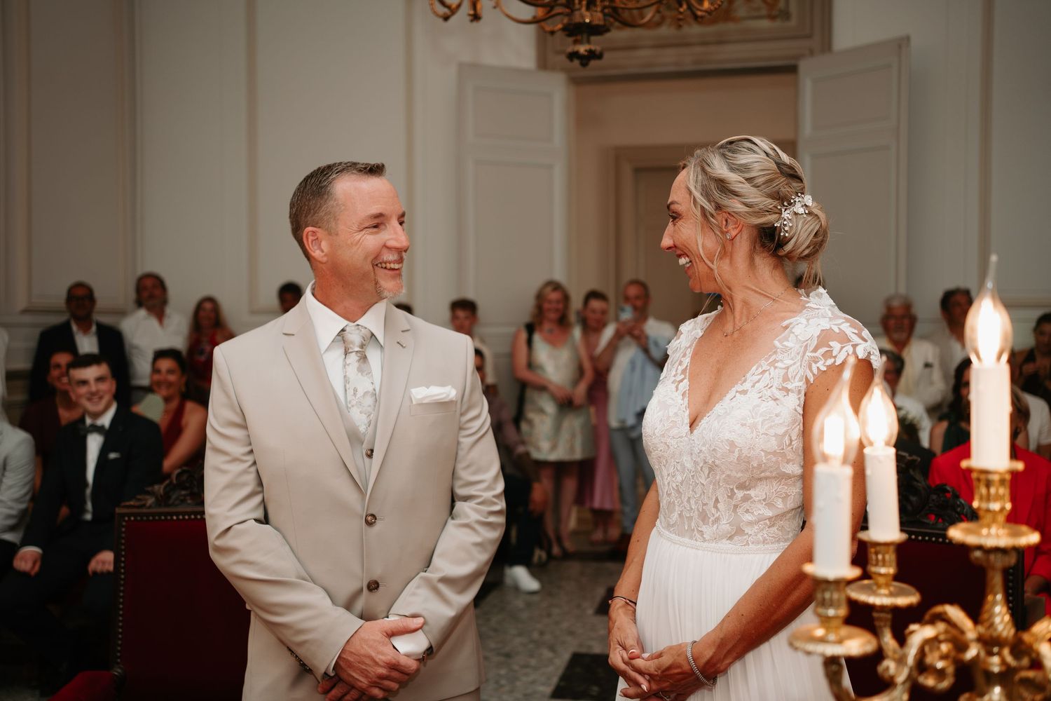 A bride and groom share their first dance at an elegant wedding reception with candlelit decor.