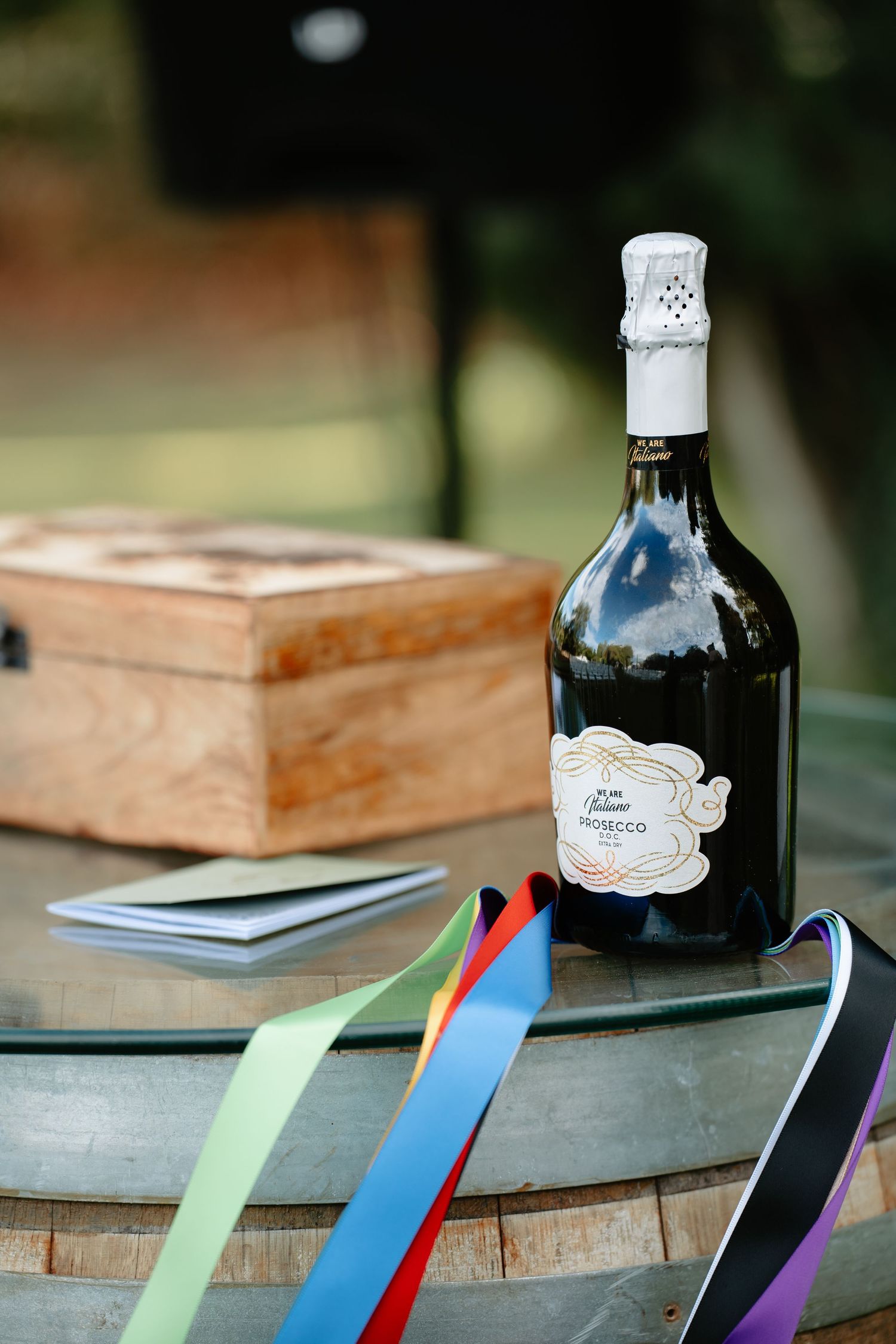 A sequence of wooden blocks and glass bottles decorated with colorful ribbons arranged on a rustic surface.
