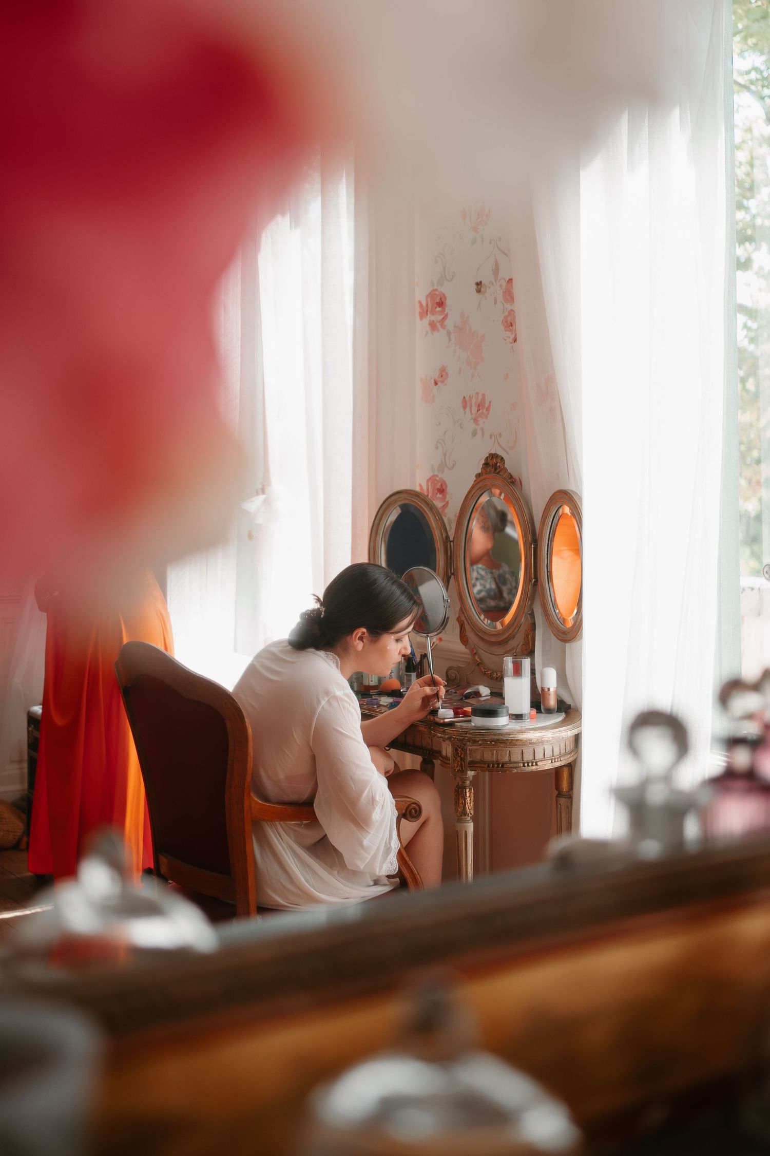 A series of dreamy boudoir photos showing a person sitting at a vintage vanity in soft morning light.