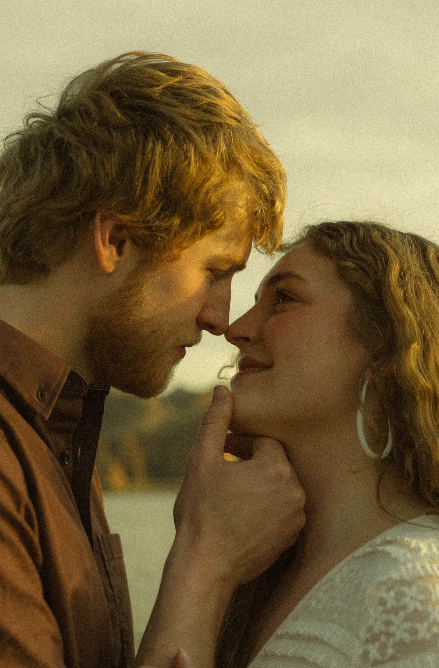 A romantic sequence shows a couple in a tender embrace against a golden sunset backdrop.