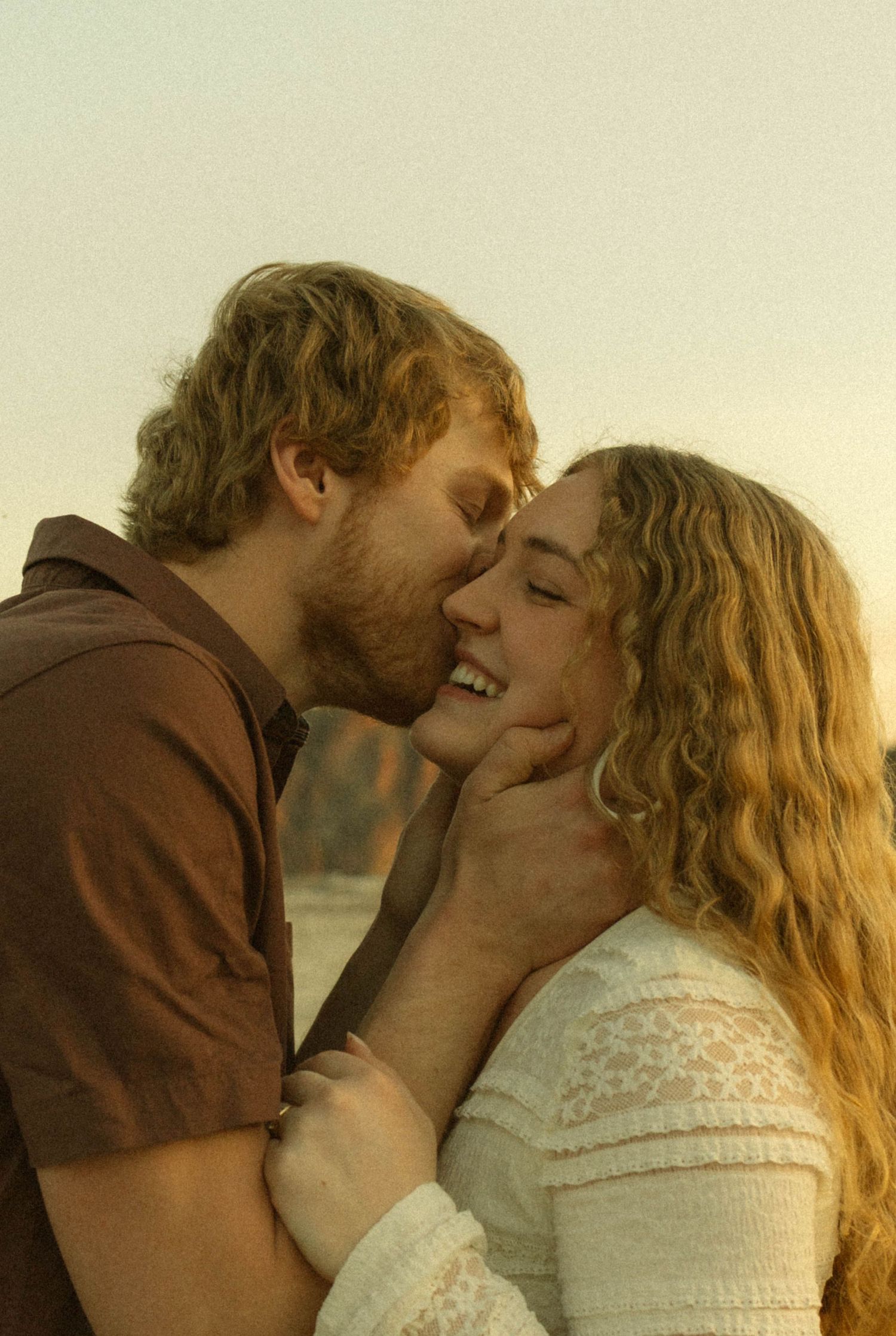 A romantic couple embraces in a series of intimate photos showing their tender connection in warm sunlight.