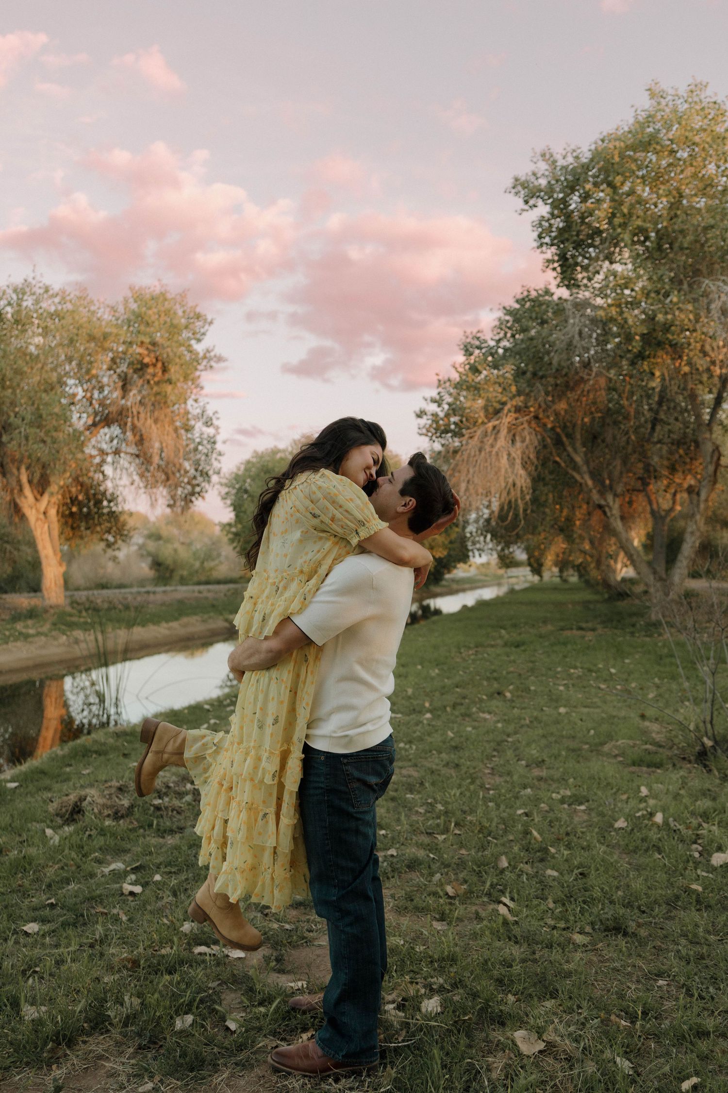 A sunset photoshoot sequence showing romantic embraces under autumn trees near a river.