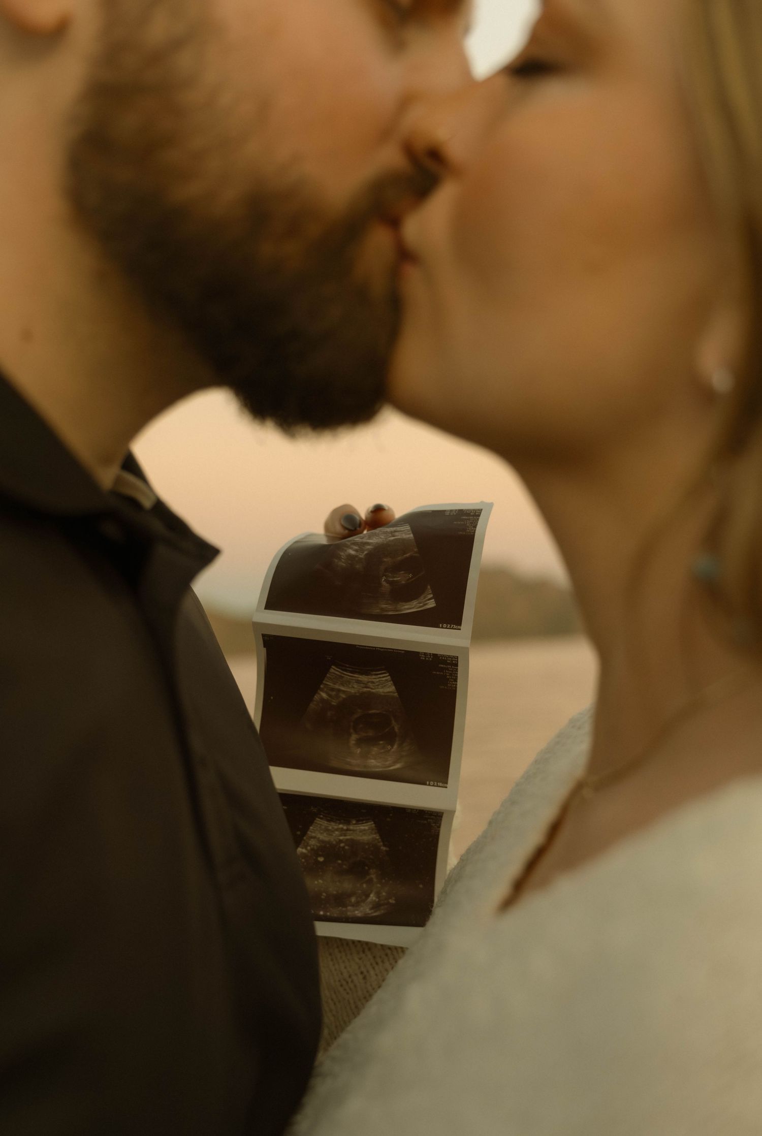 An intimate moment captured with ultrasound photos held in the foreground.