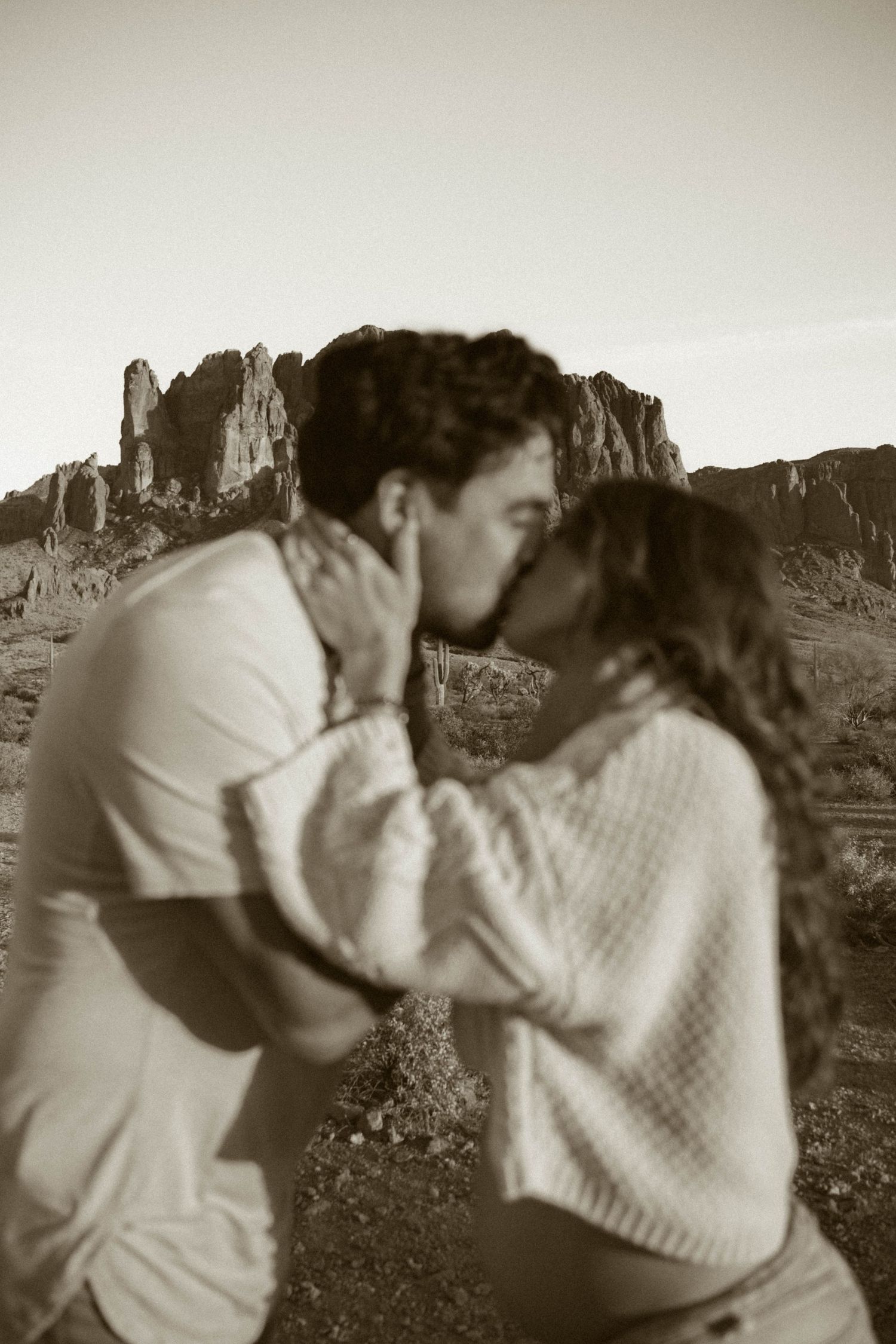 An intimate black and white photo sequence with desert cliffs in the distance.