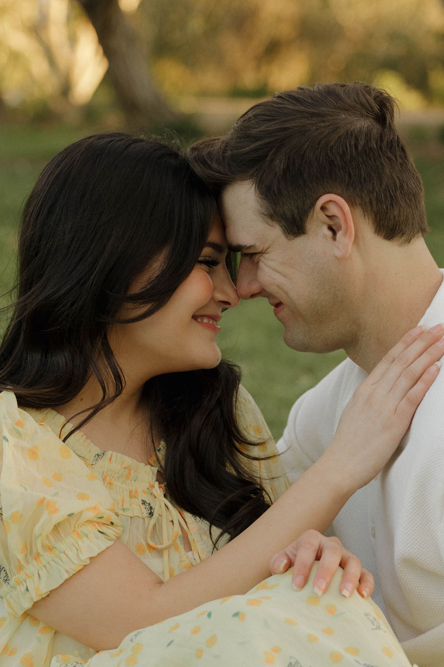 A romantic couple in a yellow dress and white shirt share intimate moments in a series of outdoor portrait photos.