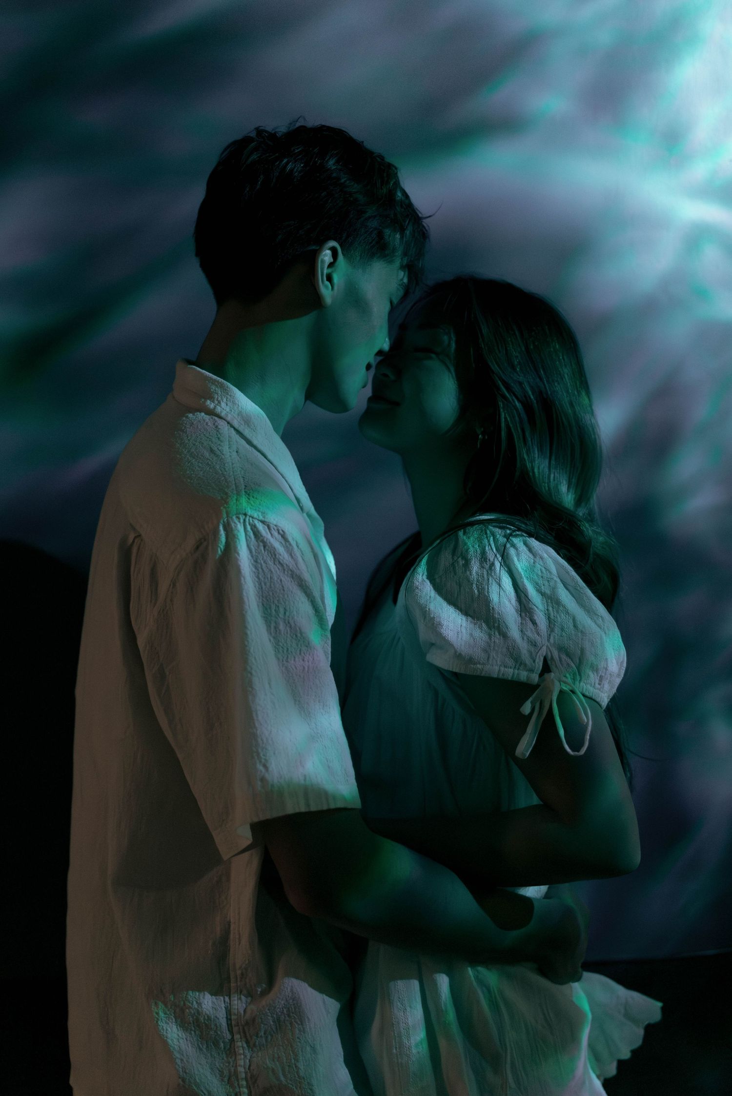 A series of intimate silhouettes showing a couple embracing in moody blue lighting.