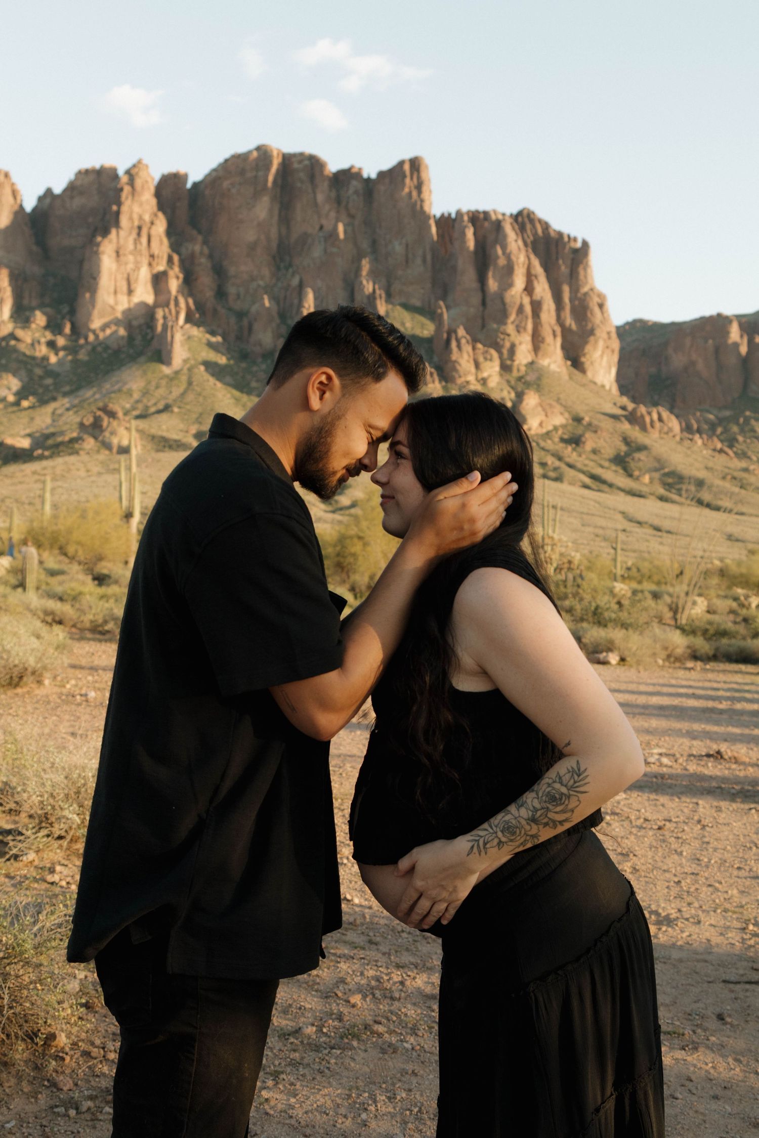 A couple shares intimate moments in front of the majestic Superstition Mountains during golden hour in Arizona.