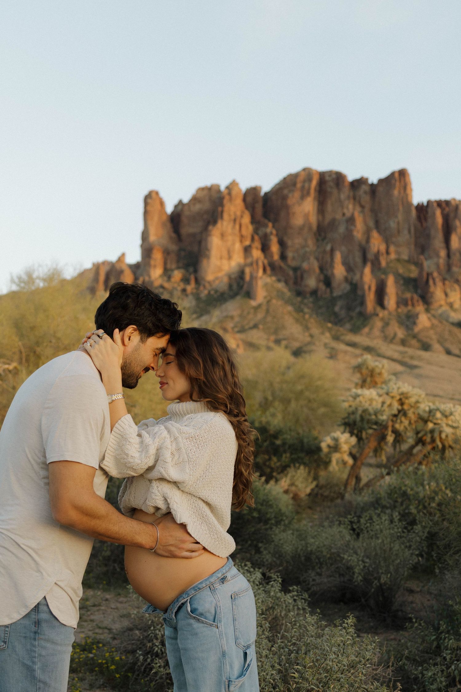 A romantic desert photoshoot with dramatic mountain formations in the background.