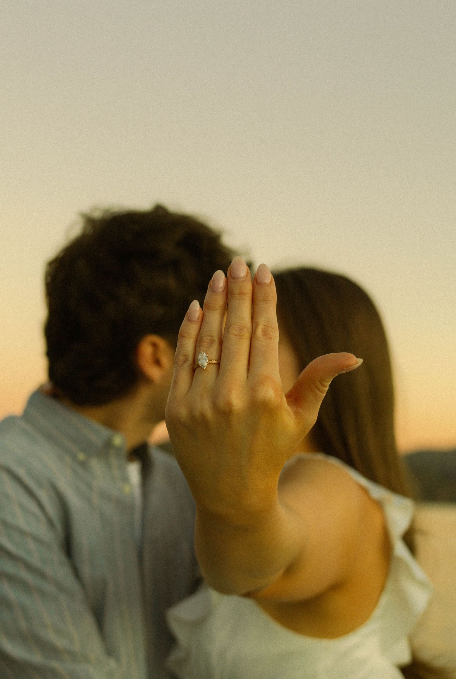 A series of six similar photos showing a couple embracing while one person covers their face with their hand at sunset.