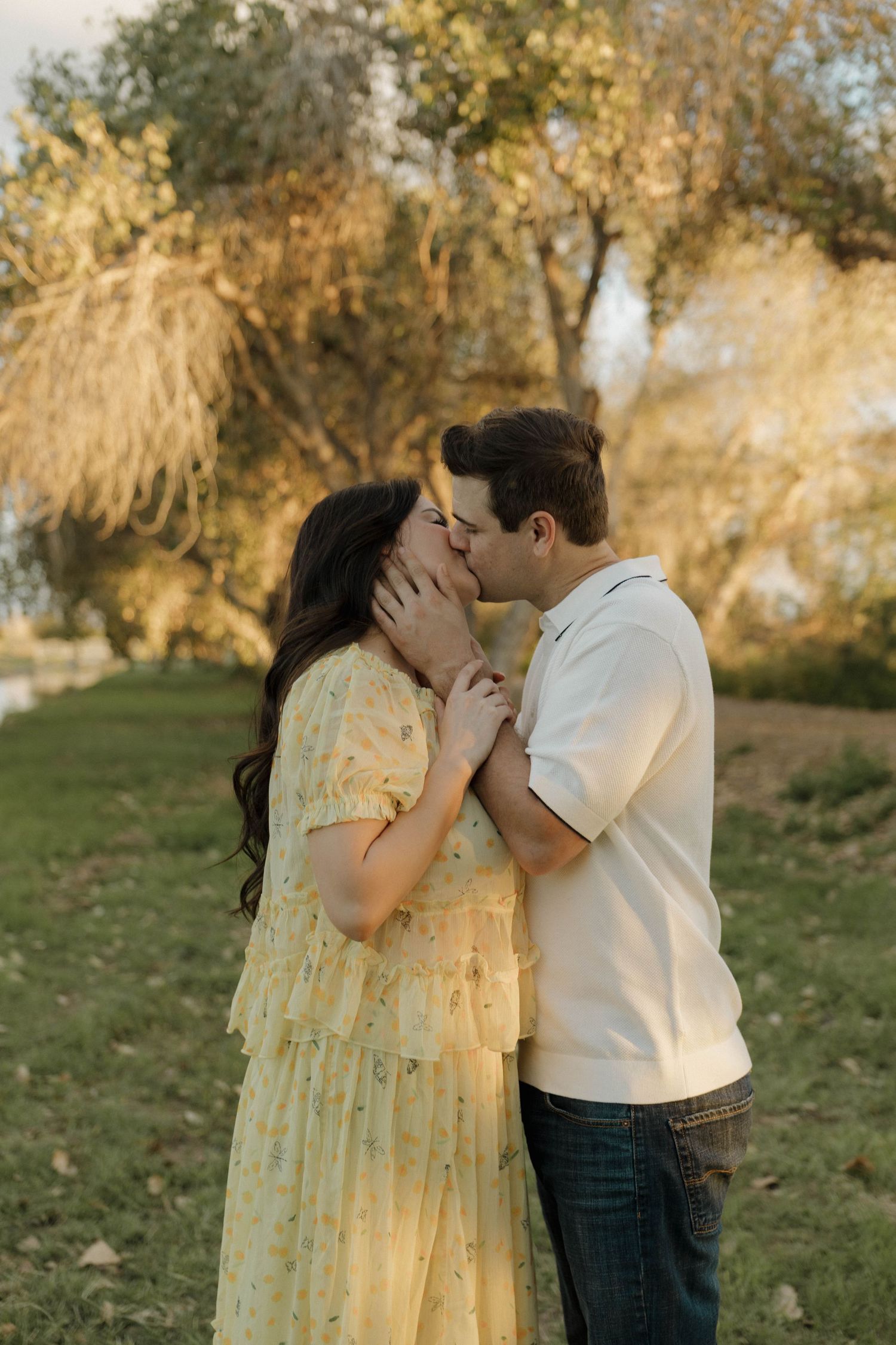 A romantic sequence of tender moments between a couple in yellow dress and white shirt against a pastoral backdrop.