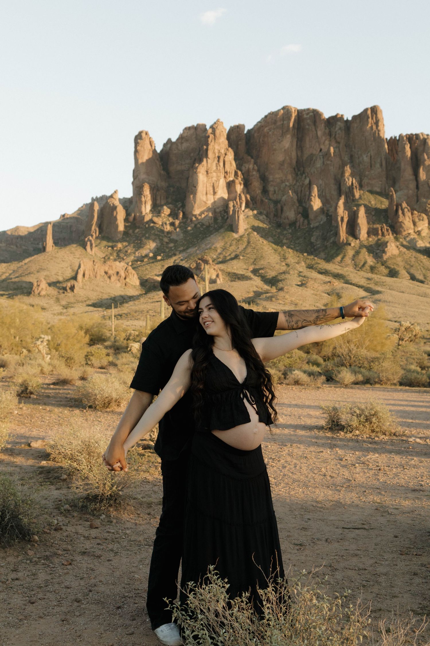 Romantic desert photoshoot with dramatic rock formations in the Superstition Mountains at sunset.