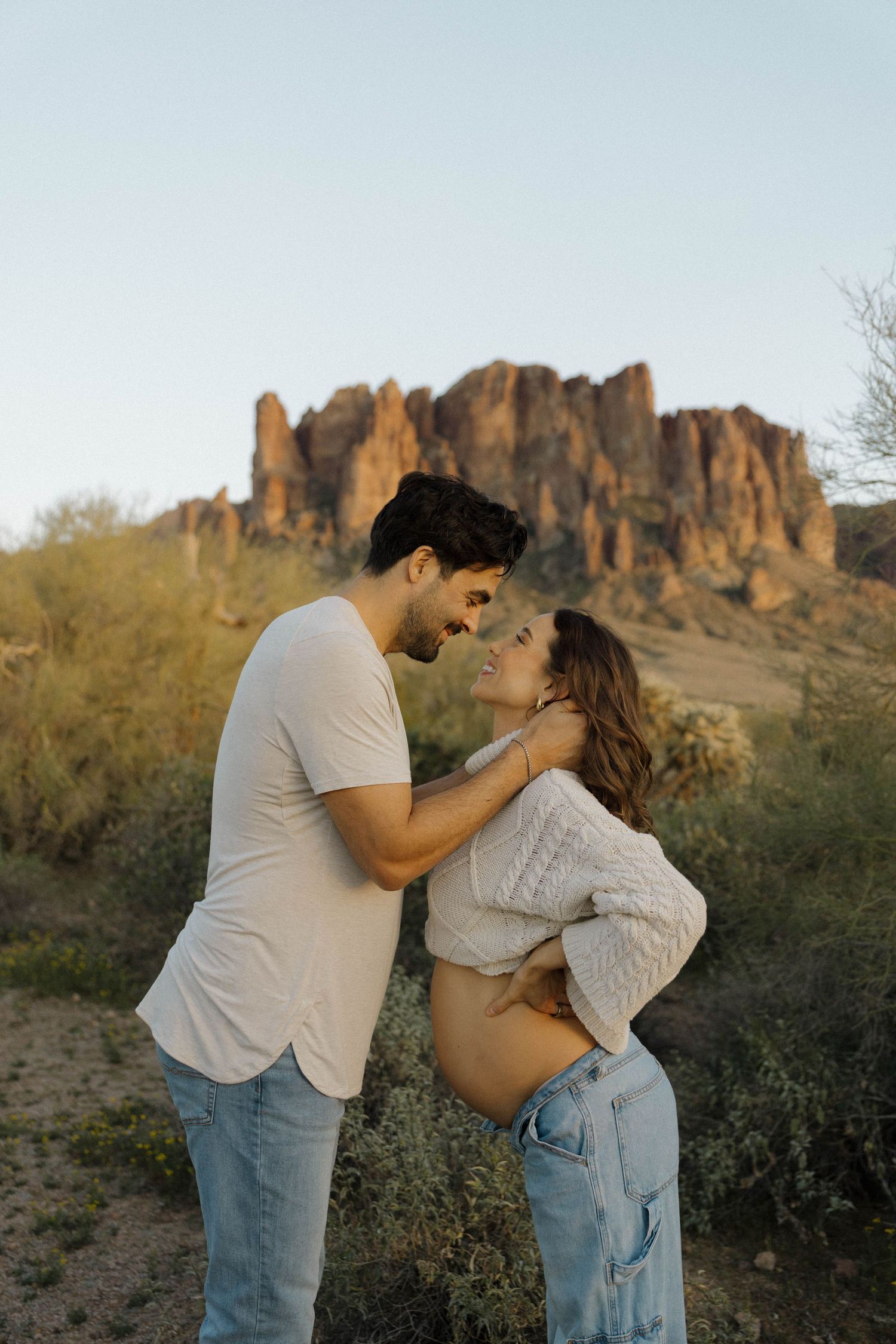 Intimate moment captured between a couple with the Superstition Mountains rising dramatically behind them.