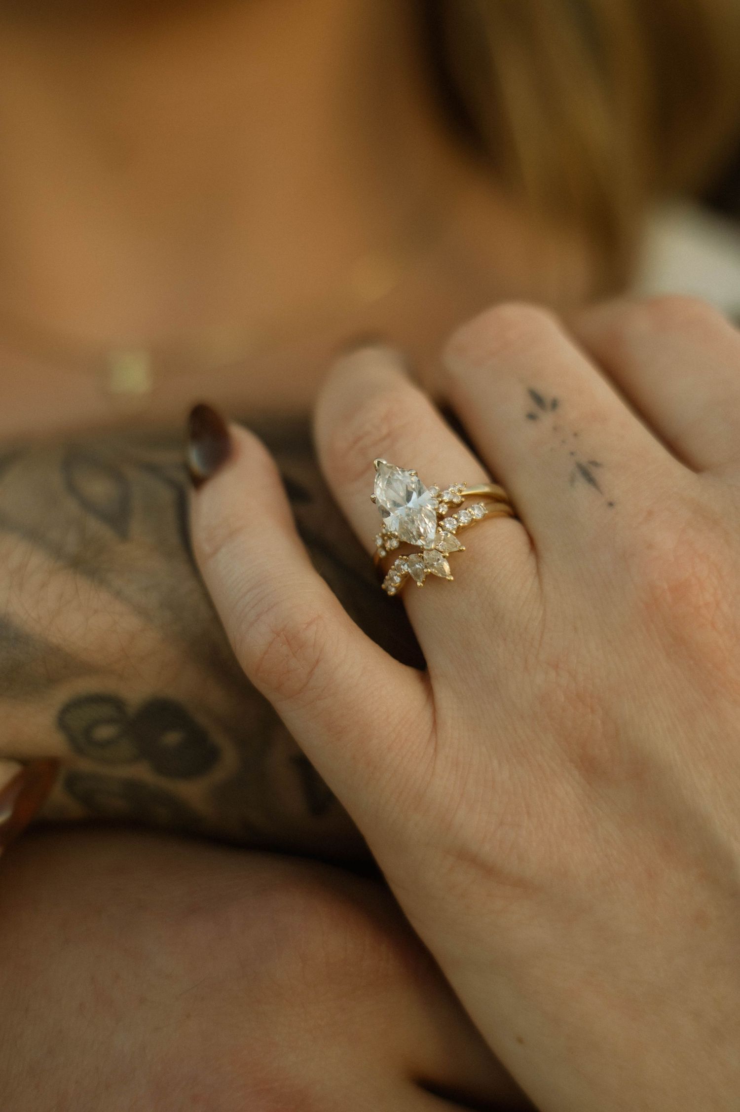 Close-up shot of hands wearing delicate diamond rings with star-shaped designs.