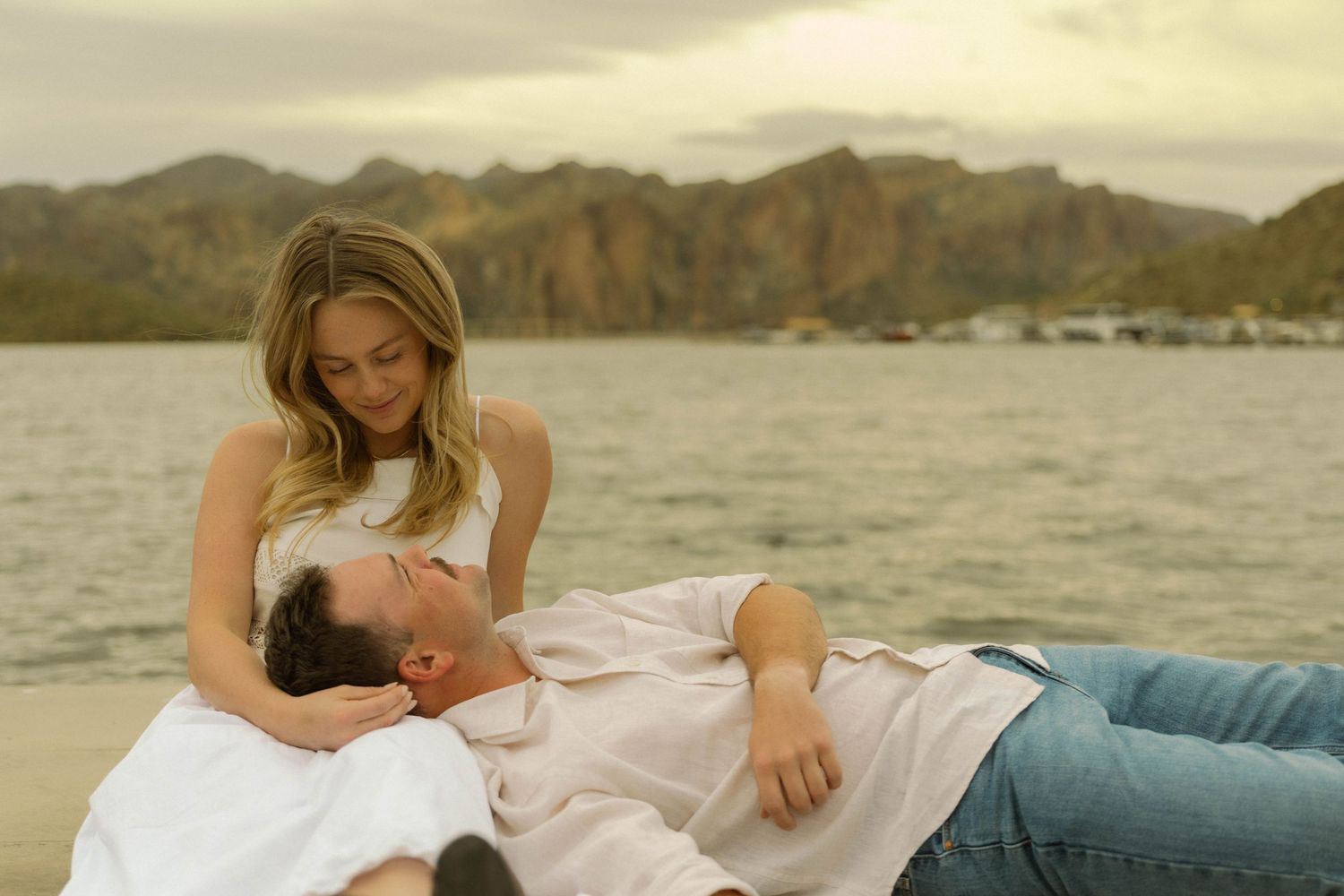 A series of intimate family moments on a beach at sunset with a mother and newborn baby.