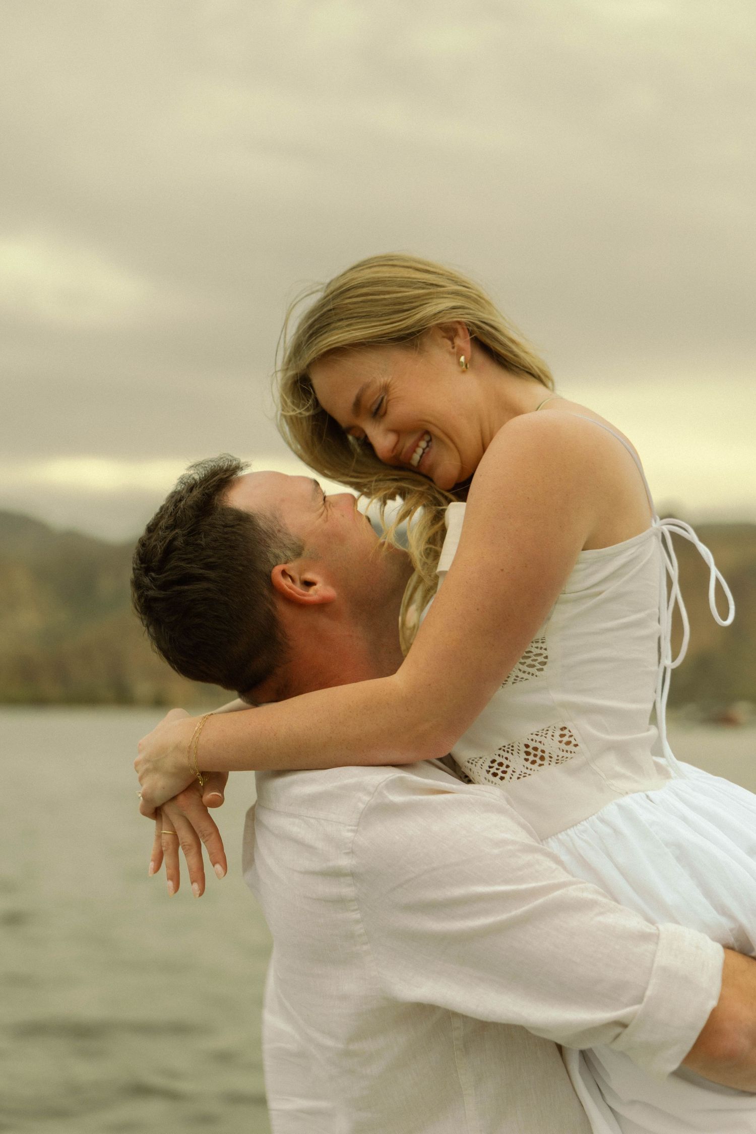 Joyful couple sharing romantic dance moves by scenic lake.