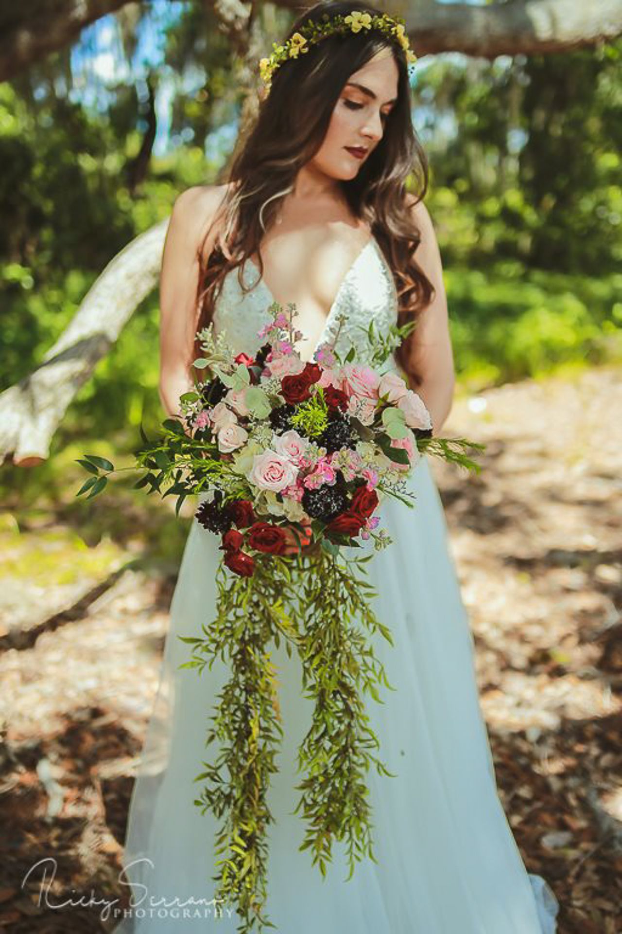 Ethereal bridal portrait with flowing mint dress and cascading burgundy floral bouquet.