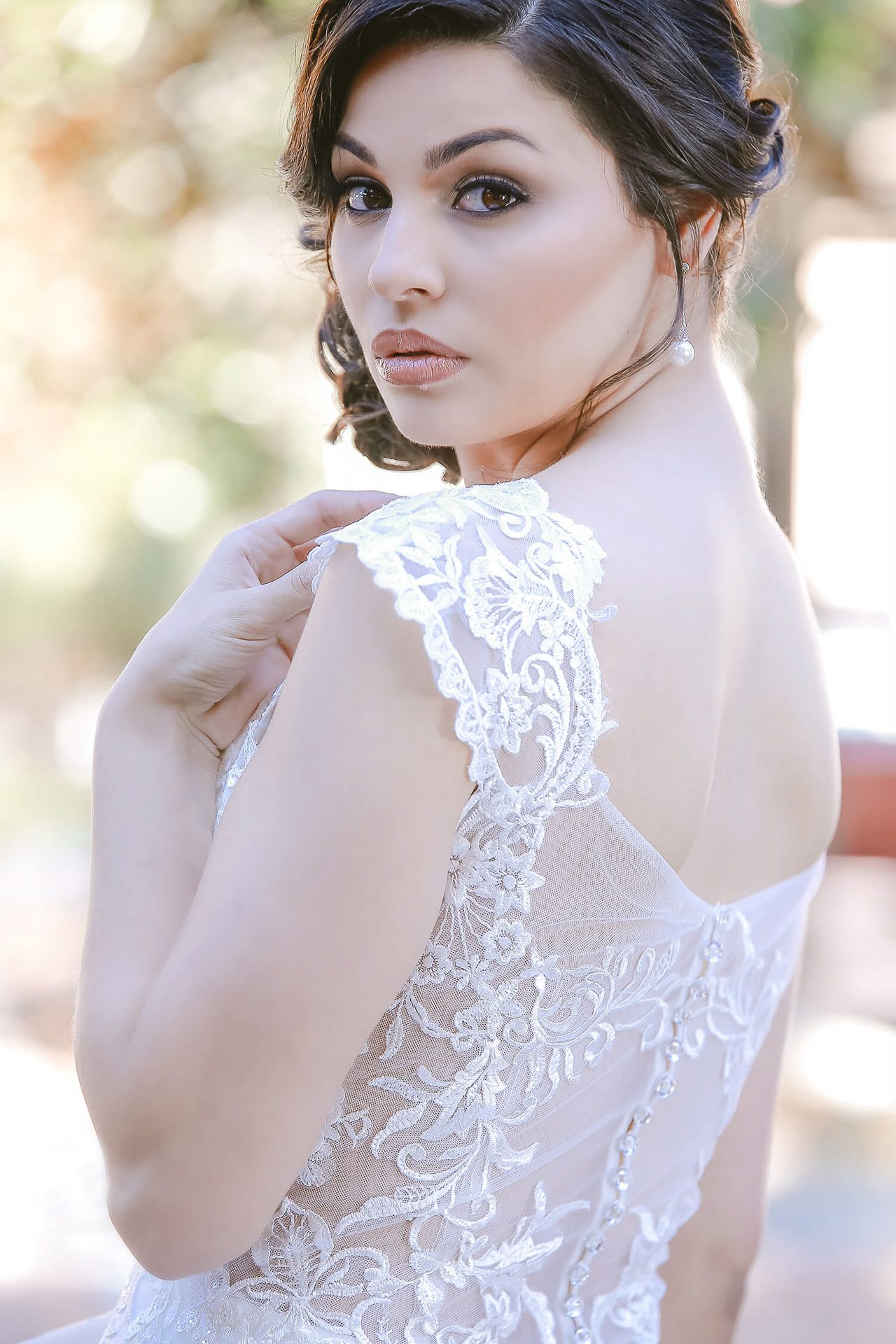Close-up bridal portrait showing intricate lace detail on back of wedding gown.