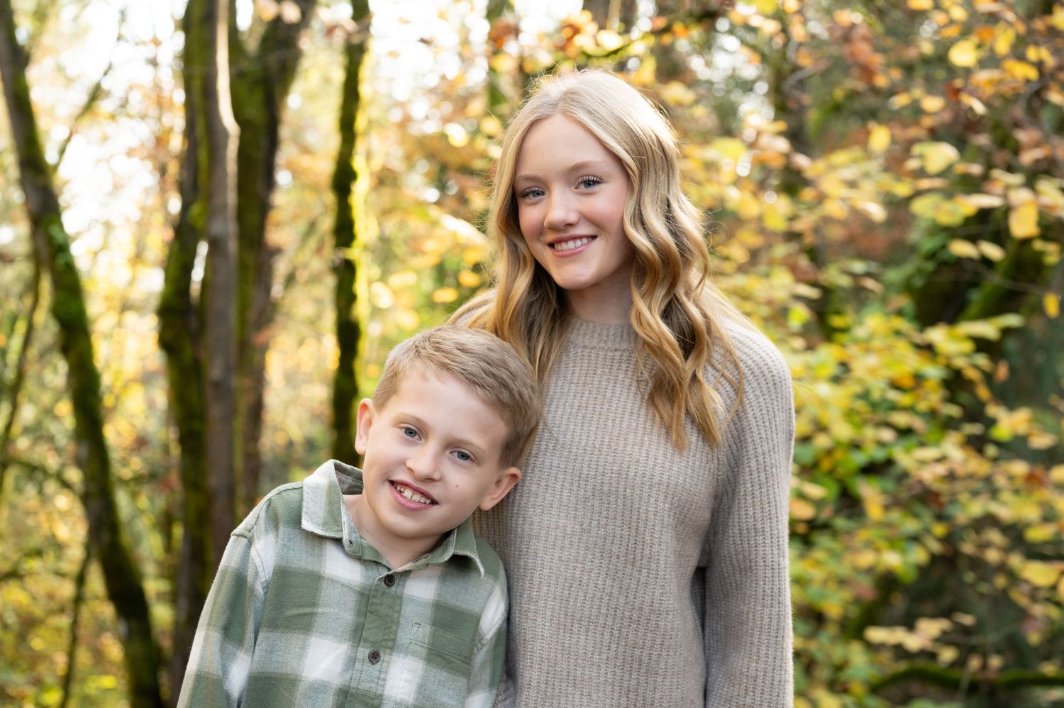 Casual outdoor family photo session with autumn trees and fallen leaves creating a natural backdrop. Family session. Portrait photography.