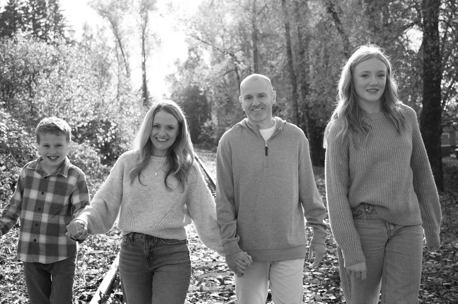 Family portrait session outdoors with multiple groups posing together in casual attire against natural backdrop. Family session. Portrait ph