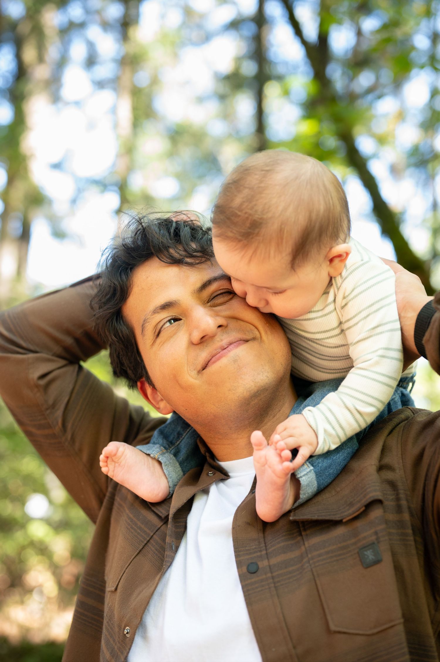 Joyful interaction between parent and baby outdoors with natural bokeh background. Family session. Portrait photography. Oregon.