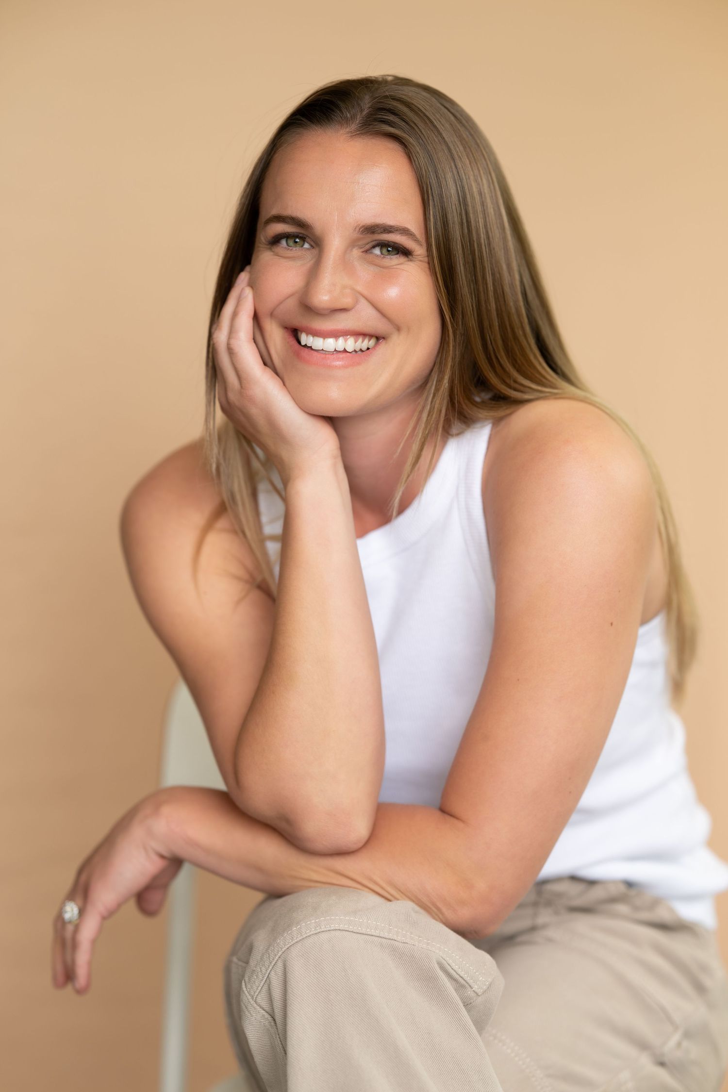Casual portrait series against beige background showing relaxed poses in white tank top.