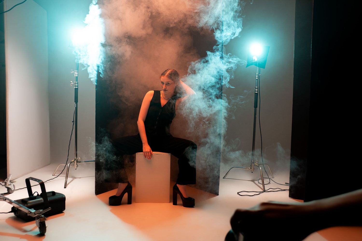 Dramatic studio photography setup with blue smoke effects and lighting equipment visible. Creative portfolio. Studio. Portrait photography.