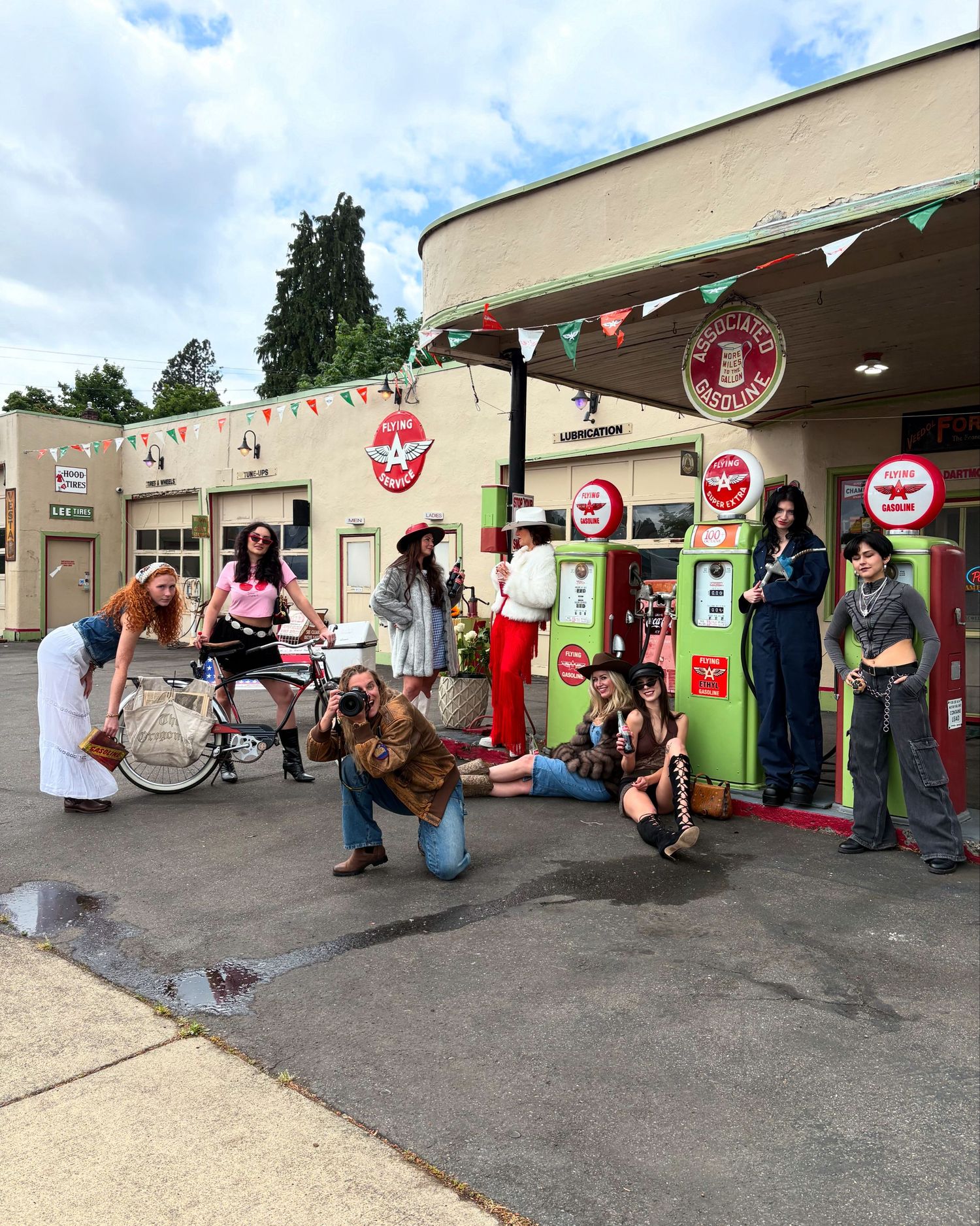People gather outside a building with colorful decorations and stop signs while musicians perform under an overhang.