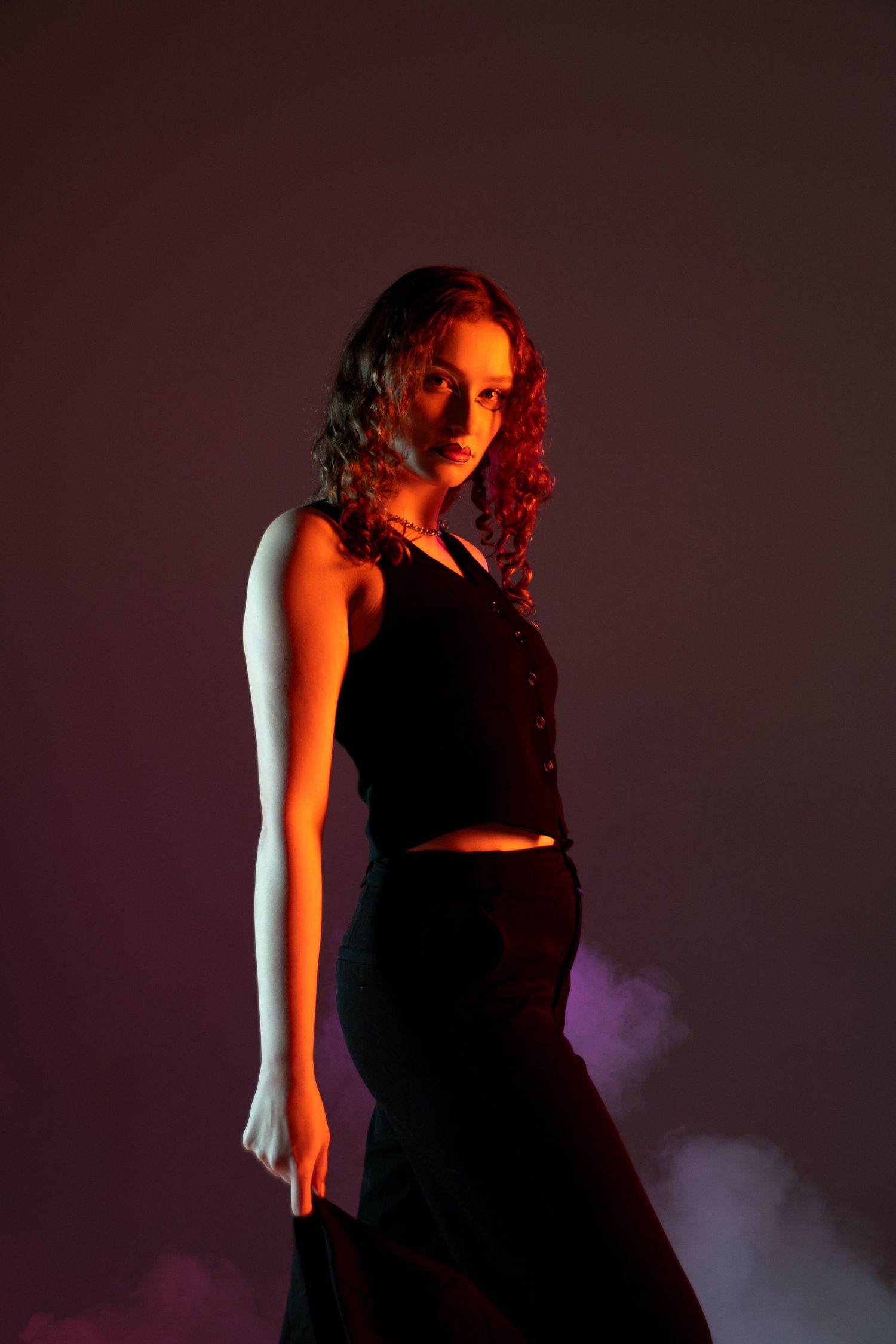 Dramatic fashion portrait with crop top and flared pants in moody red lighting. Creative portfolio. Studio. Portrait photography. Oregon.