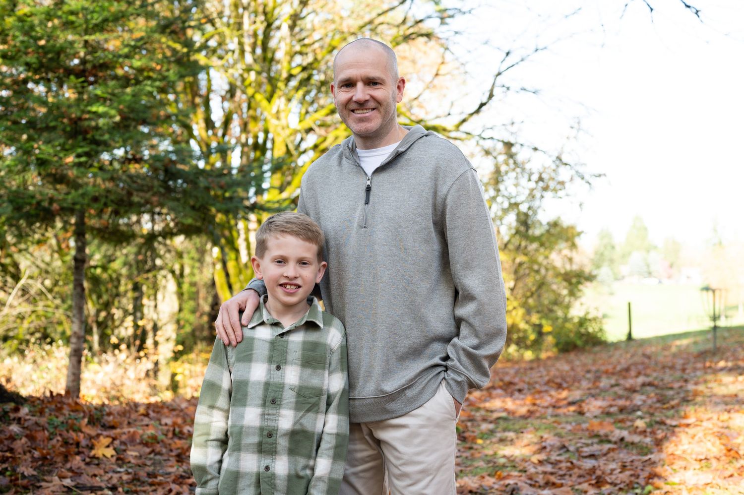 People enjoying a casual stroll through a sunlit autumn forest path. Family session. Portrait photography. Oregon.