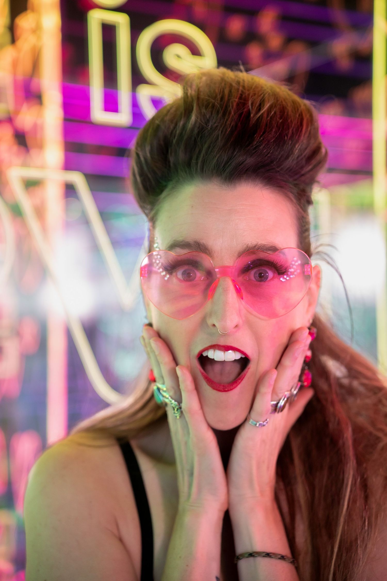 Retro-styled portrait with pink sunglasses against vibrant neon backdrop. Hopscotch. Portrait Slam.