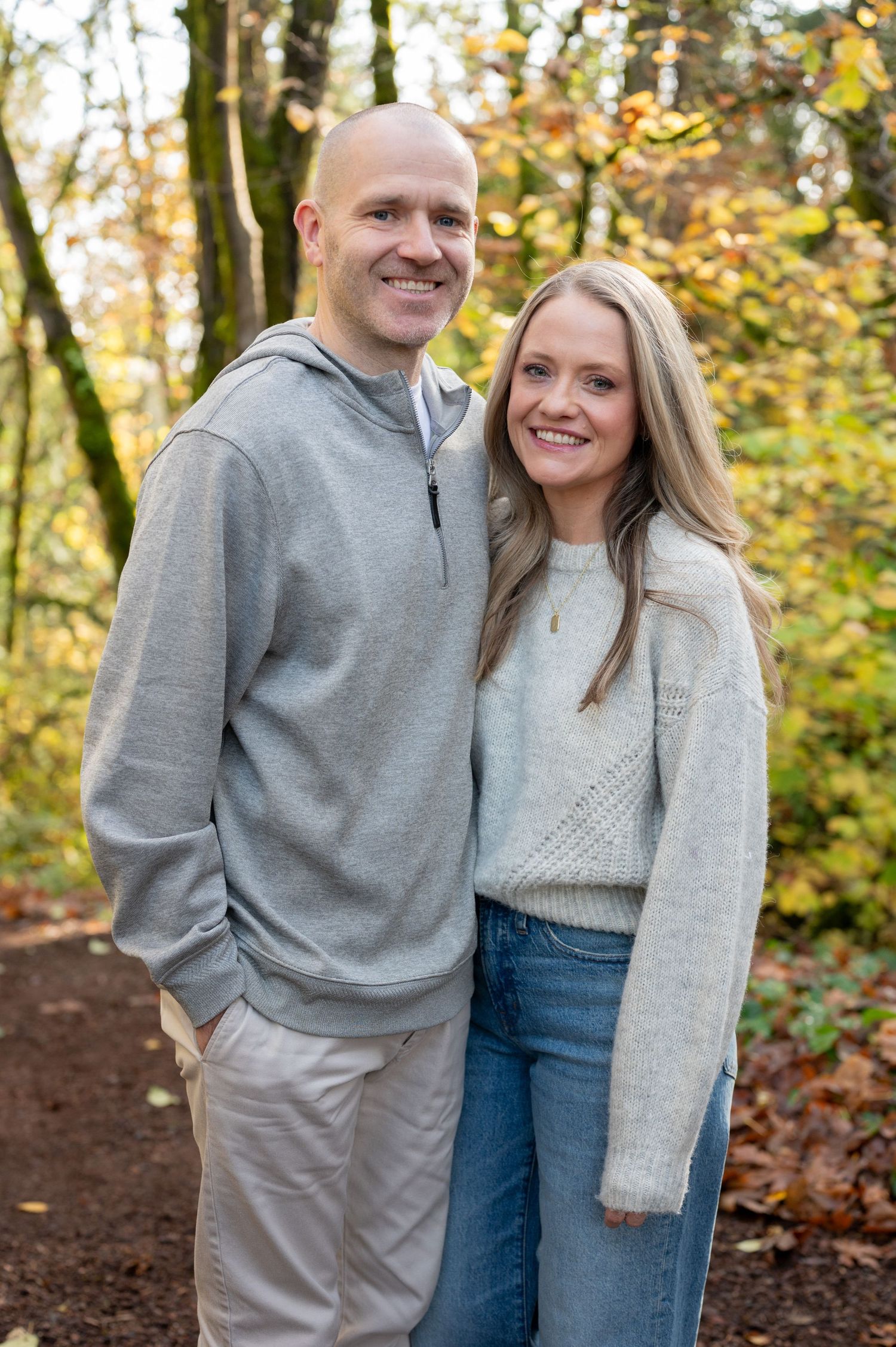 Couple in coordinating grey outfits share a candid moment during fall photo session. Family session. Portrait photography. Oregon.
