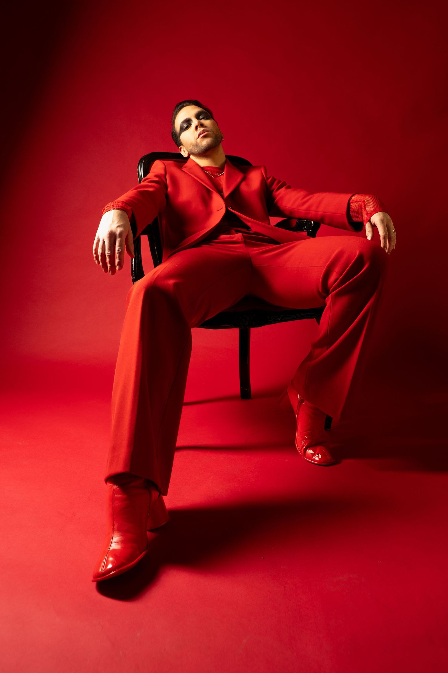 Artistic portrait series against vibrant red backdrop featuring dramatic poses in red attire.