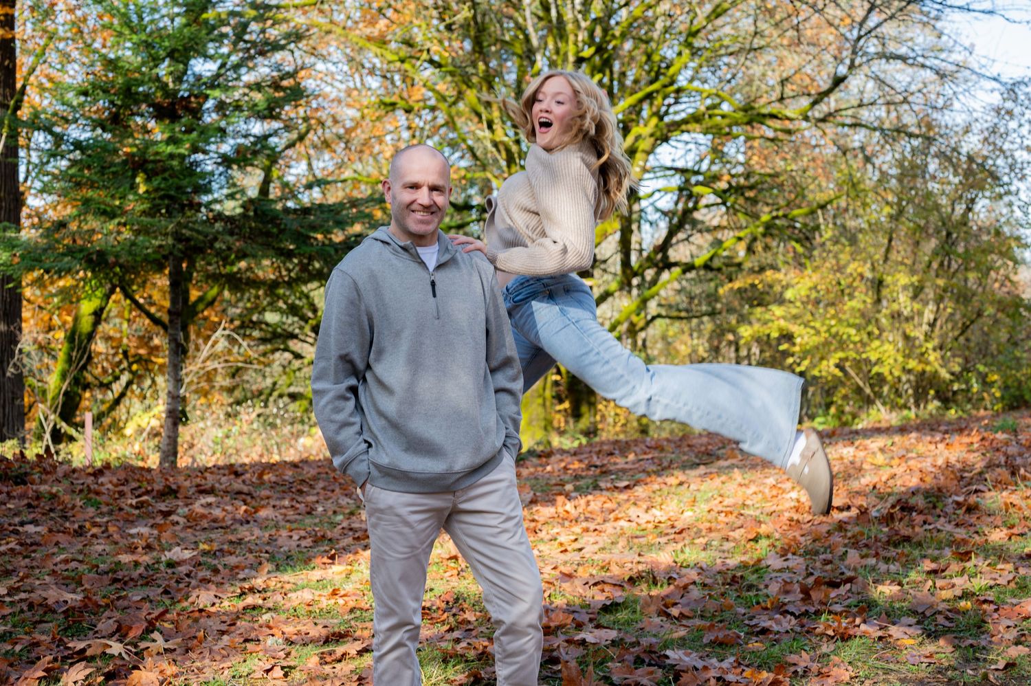People walking together on a winding forest trail during golden autumn weather. Family session. Portrait photography. Oregon.