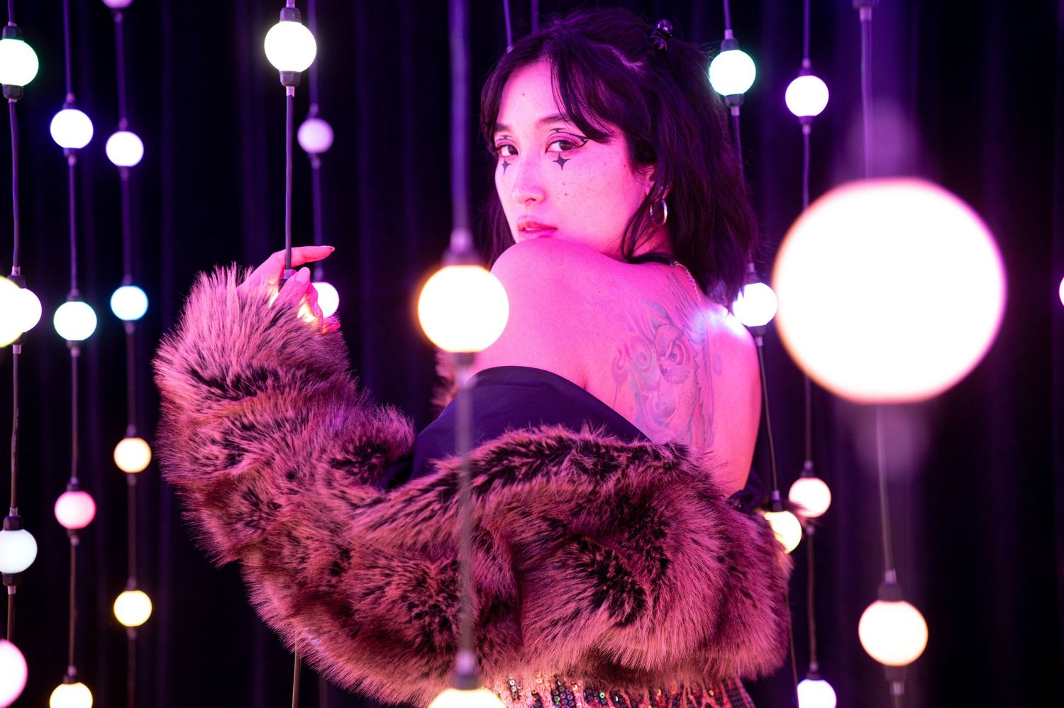 Artistic portrait with fur wrap and glowing orb lights creating a dreamy purple-lit atmosphere. Hopscotch. Portrait Slam.
