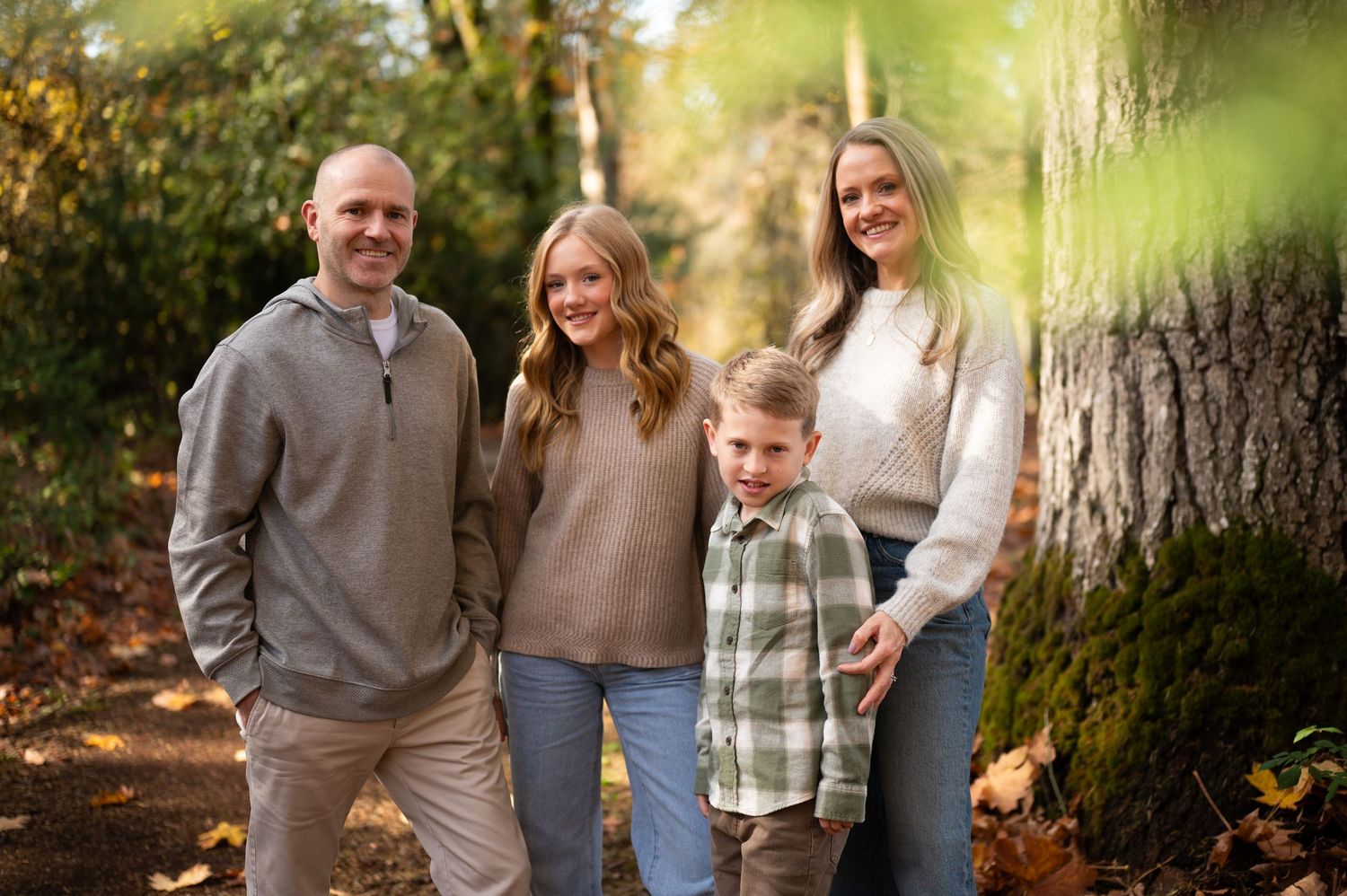 Candid family photo session through leaves and branches in golden autumn lighting. Family session. Portrait photography. Oregon.