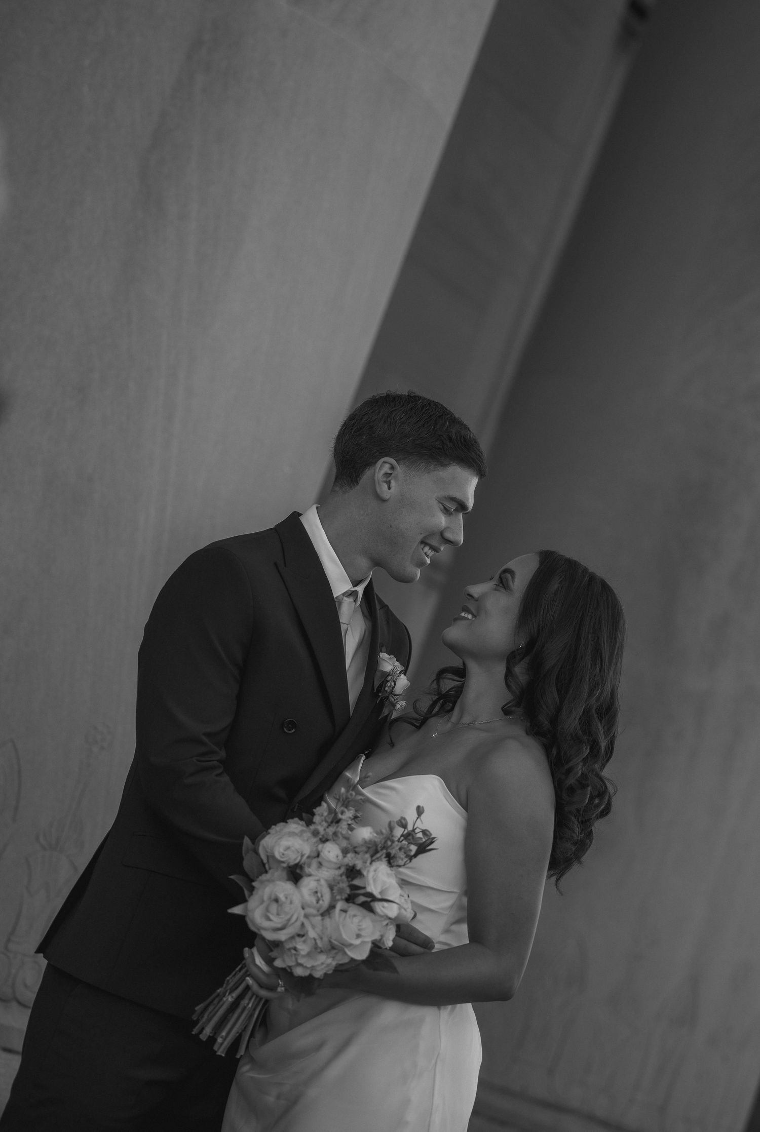 Black and white romantic portrait of bride and groom gazing at each other.