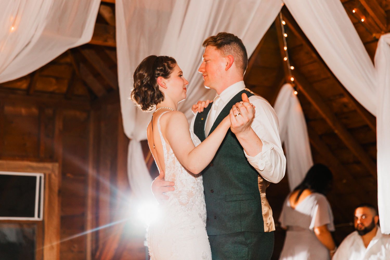 A romantic dance sequence at a wedding reception showing couples dancing under white drapes and warm lighting.