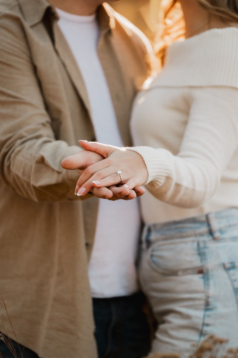 Close-up sequence showing hands reaching out to hold each other against neutral clothing.