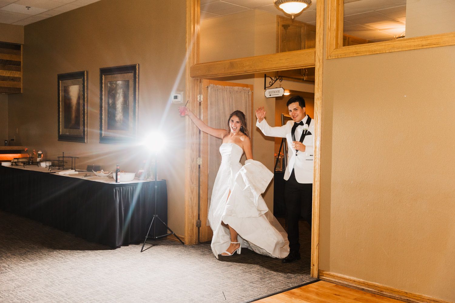 Wedding party poses in a warmly lit indoor venue creating a joyful atmosphere during celebration.