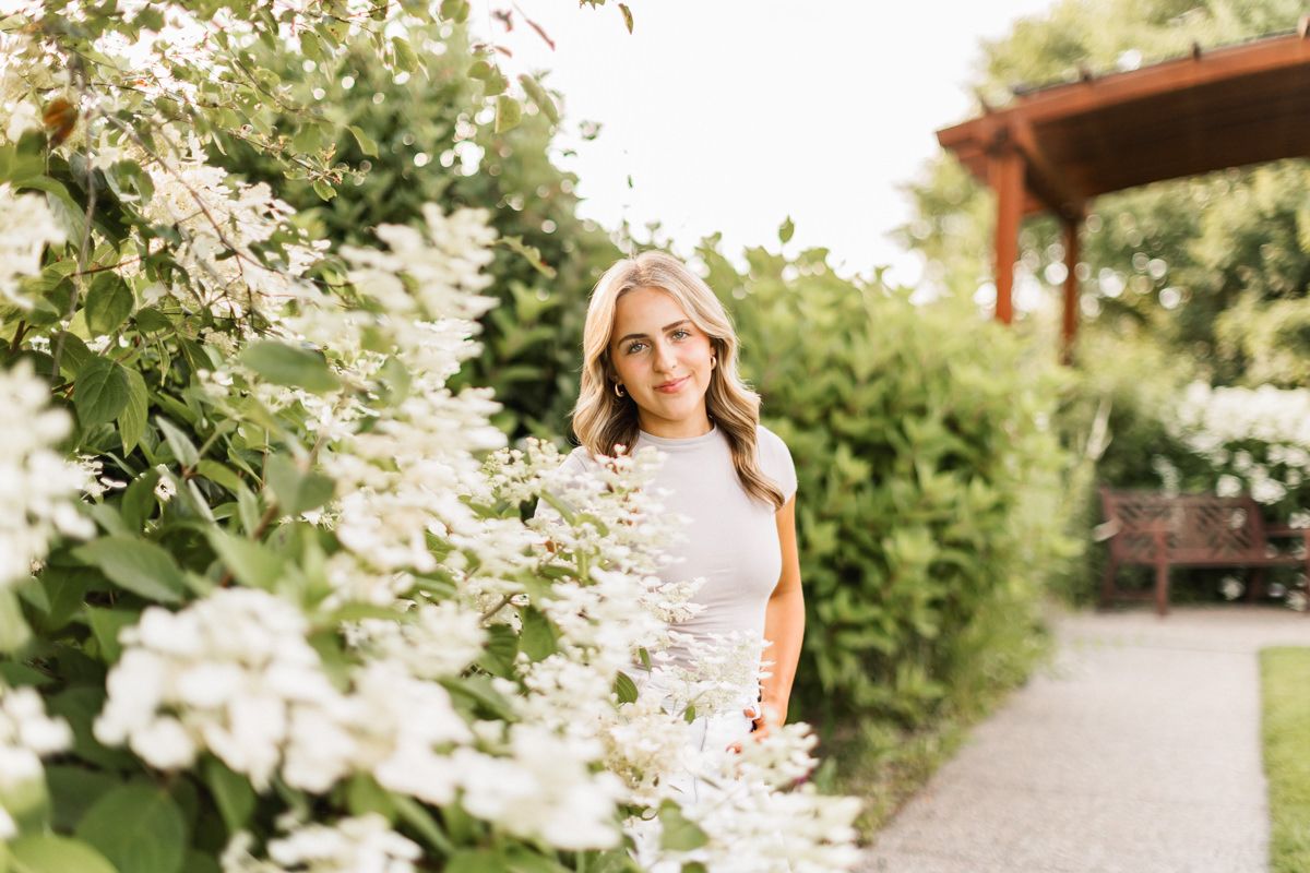 Series of outdoor portrait shots with green foliage and natural lighting in a park setting.