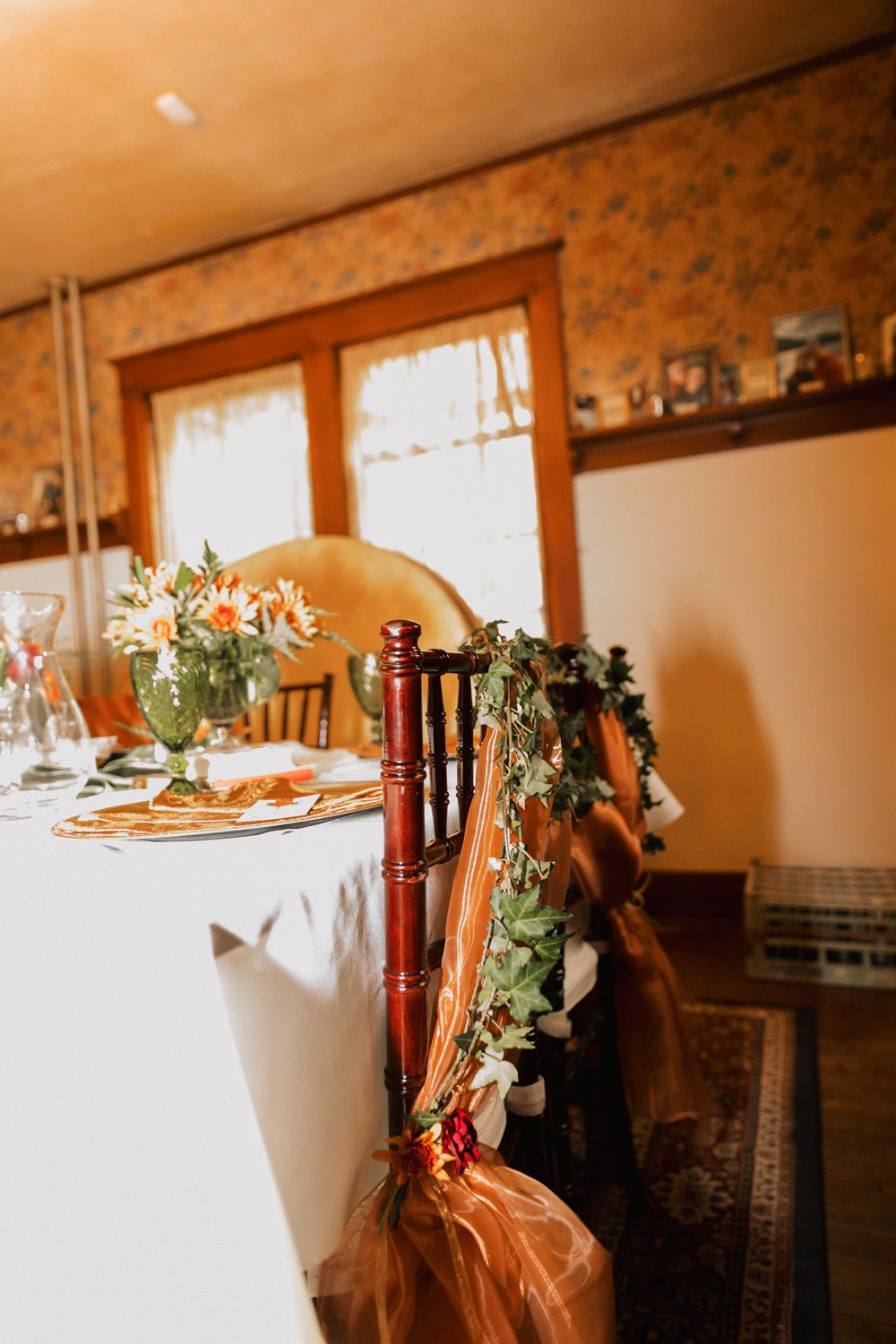 A rustic wedding reception venue with wooden beams and tables decorated with white linens and floral centerpieces.
