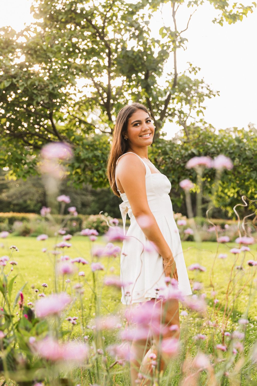 Dreamy summer portrait series in a wildflower meadow with purple blooms during golden hour.