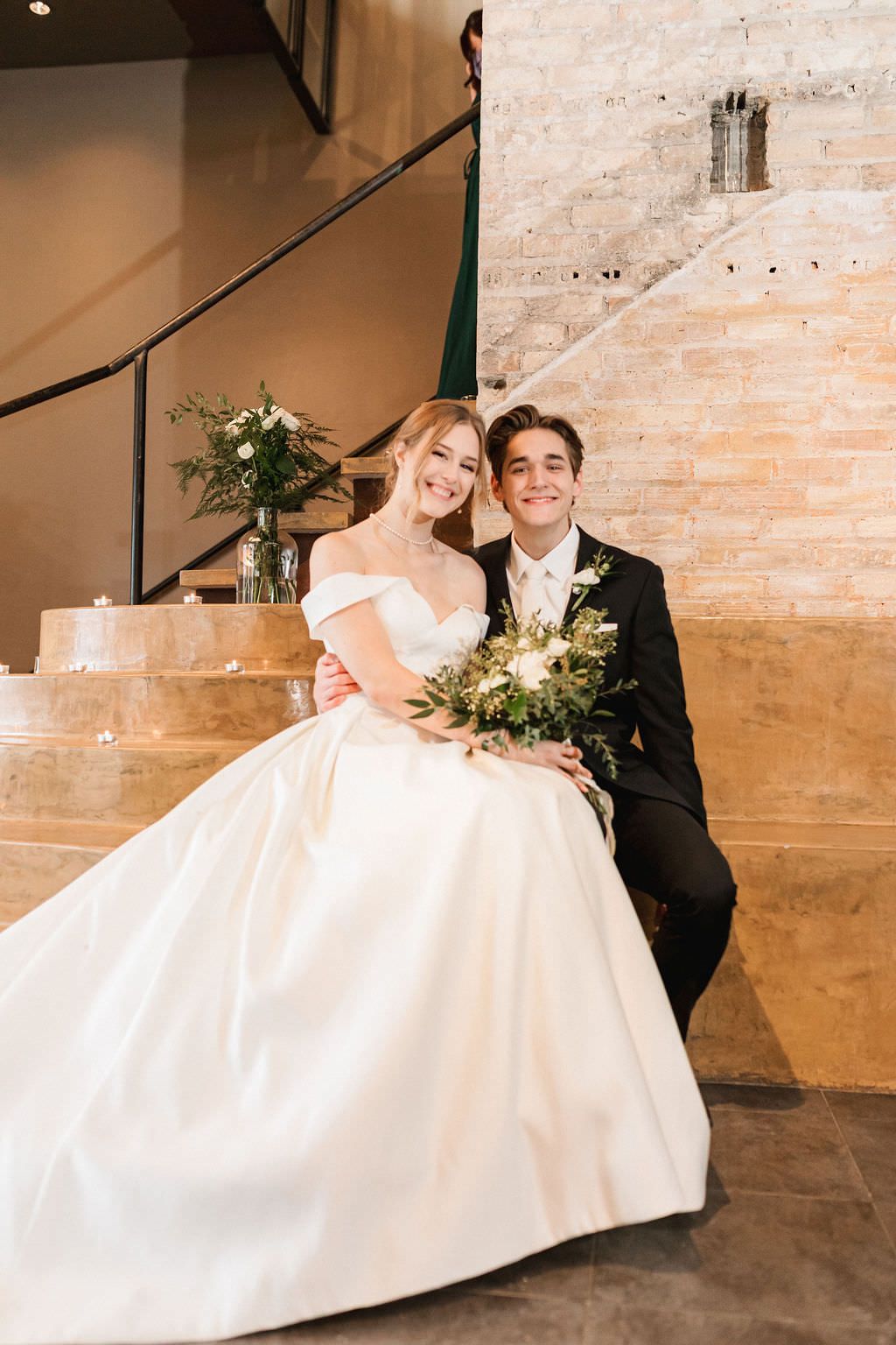 Playful dancing at a wedding venue with exposed brick walls and industrial style decor.