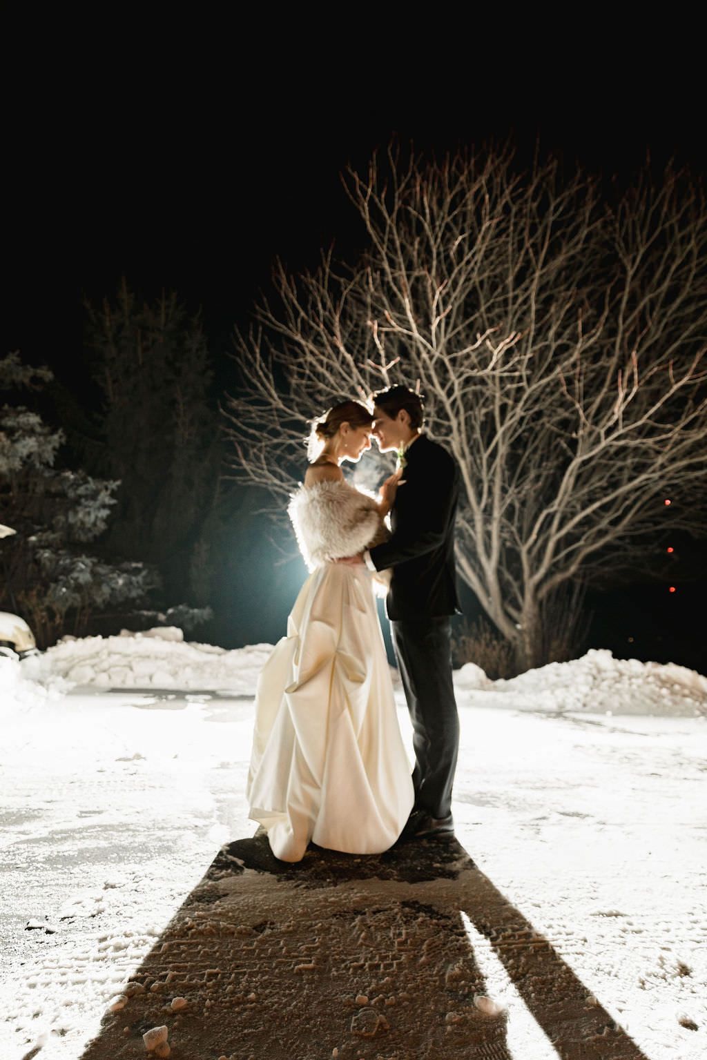 A winter night dance scene with bare trees and snow creating a dramatic silhouette.